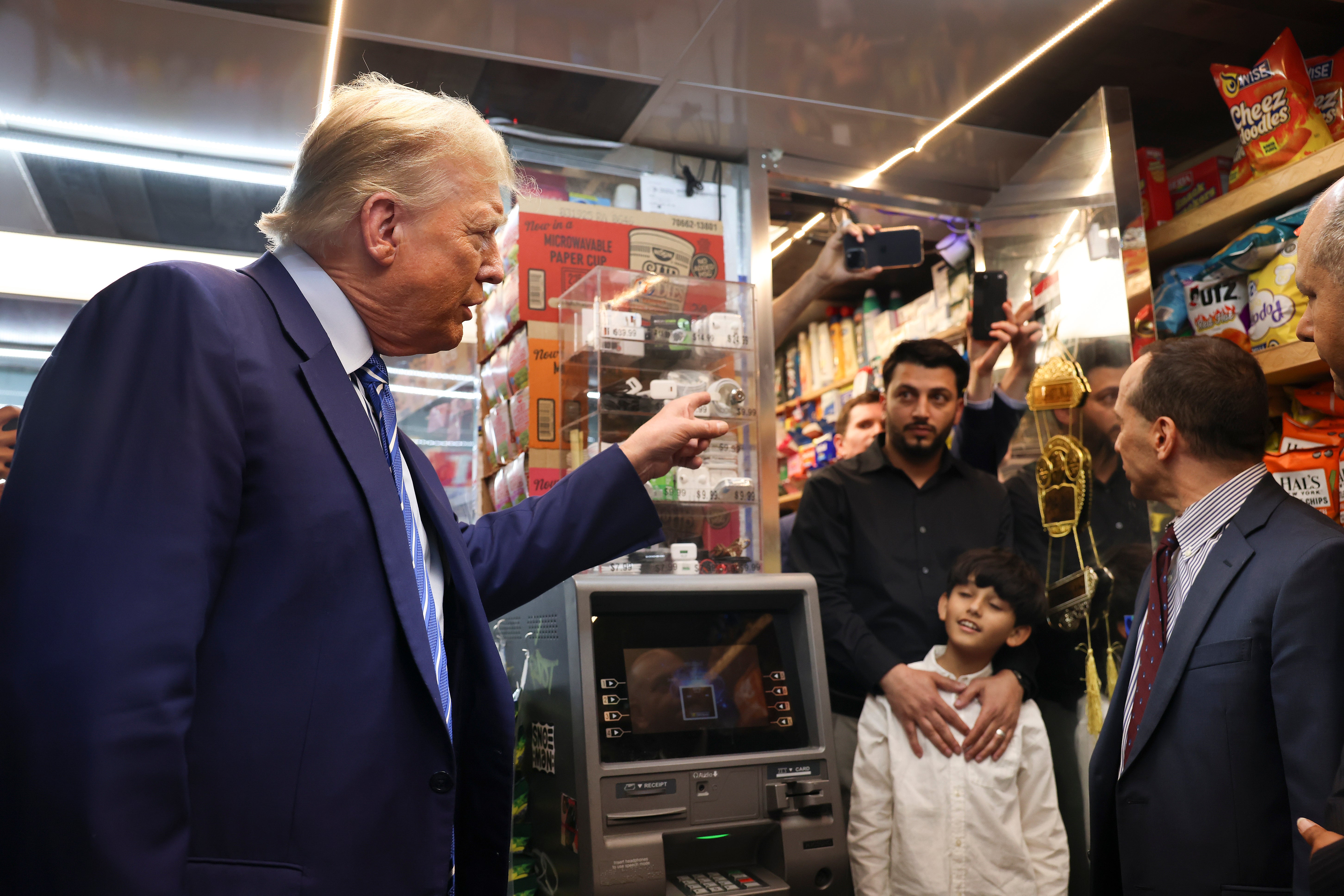 Mr Trump talks with the bodega’s owner Maad Ahmed yesterday