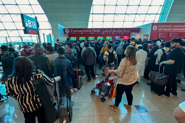 <p>Passengers queue at a flight connection desk at the Dubai International Airport in Dubai on April 17, 2024</p>