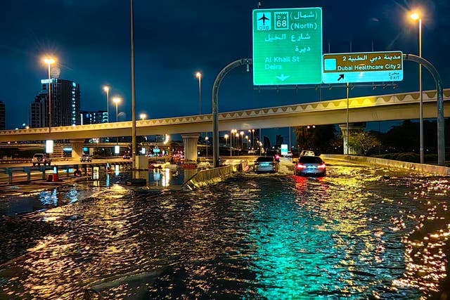 <p>Motorisits drive along a flooded street following heavy rains in Dubai </p>
