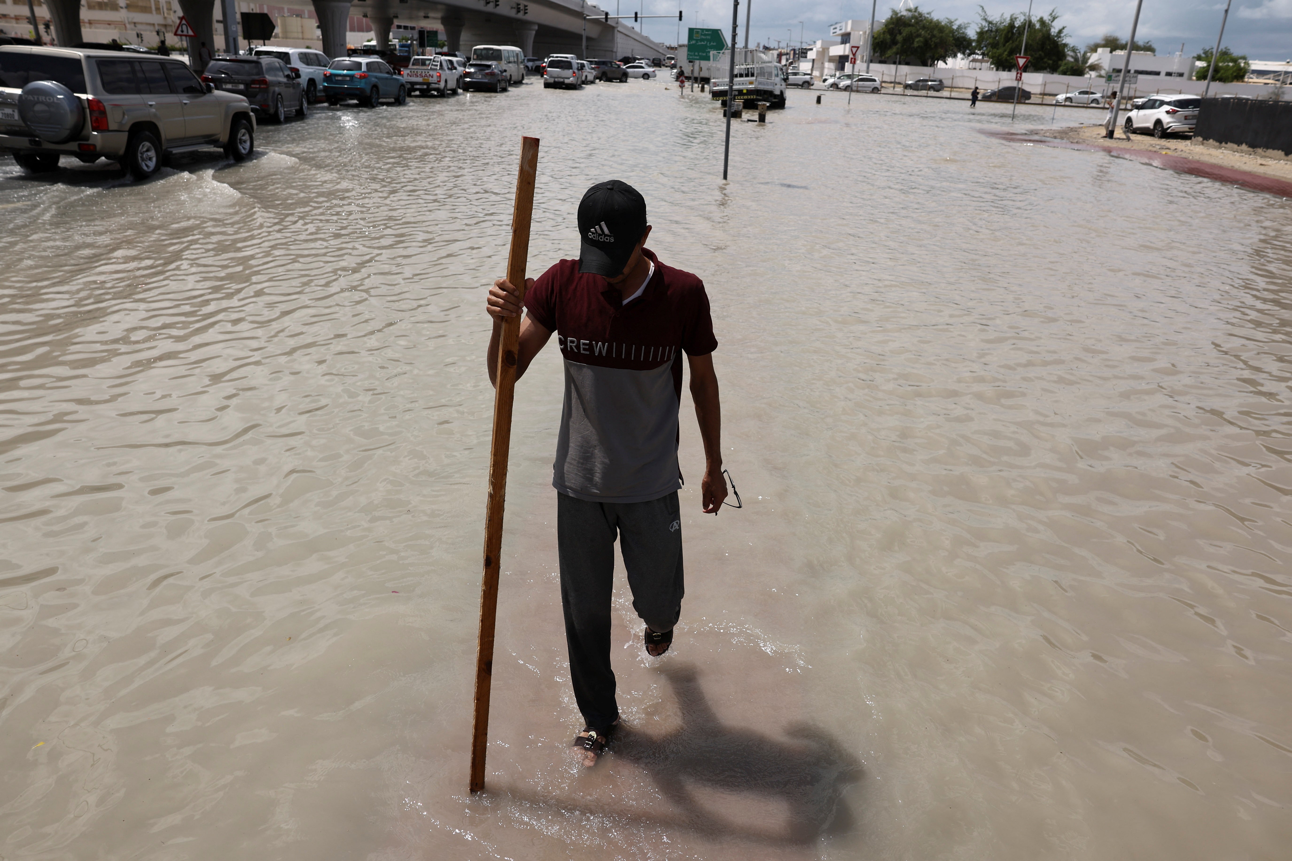 A person walks surrounded by flood water caused by heavy rains, in Dubai, United Arab Emirates