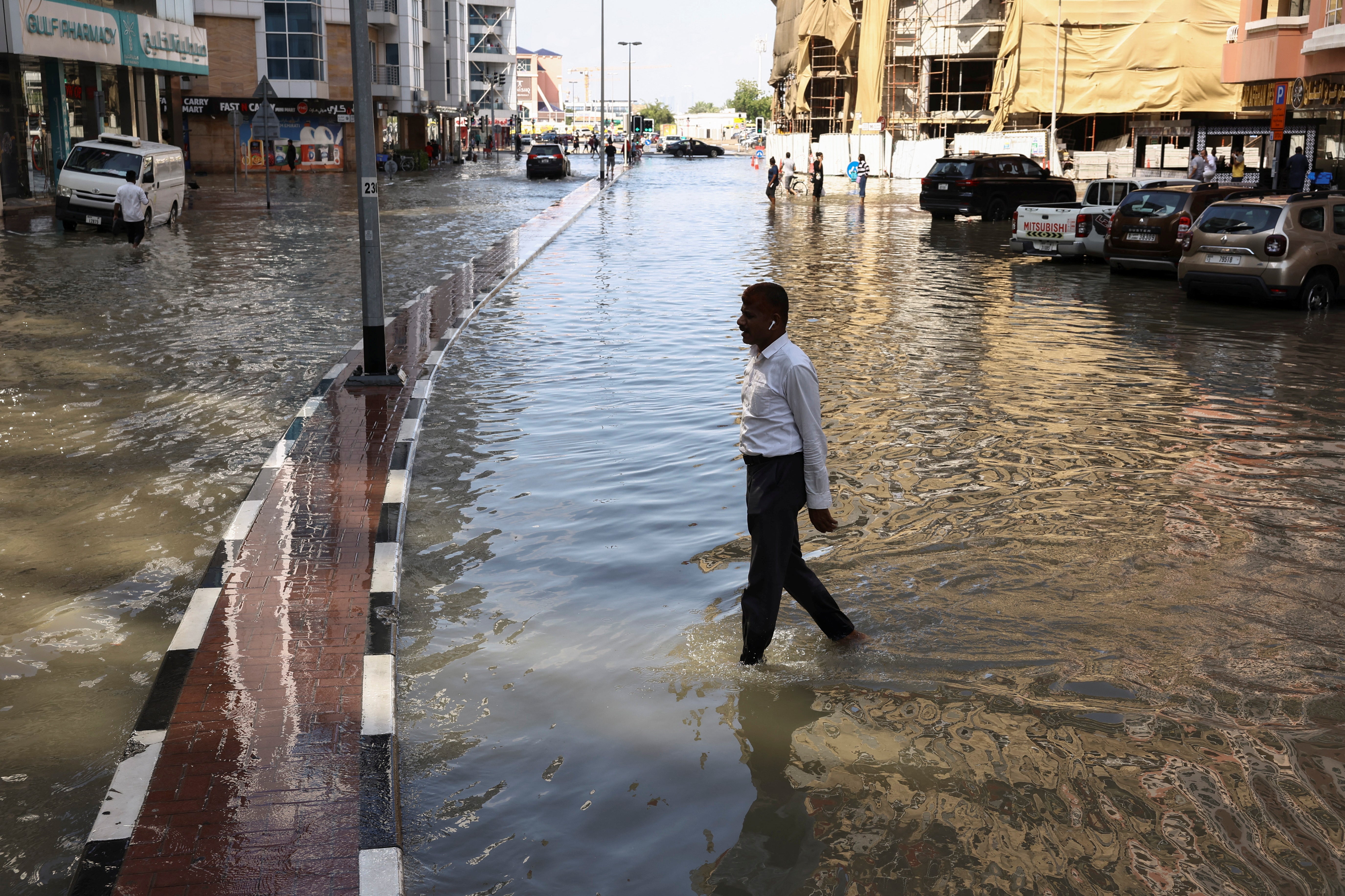 A man walks in the floodwater in the UAE, which experts are divided on as to whether it was caused by ‘cloud seeding’