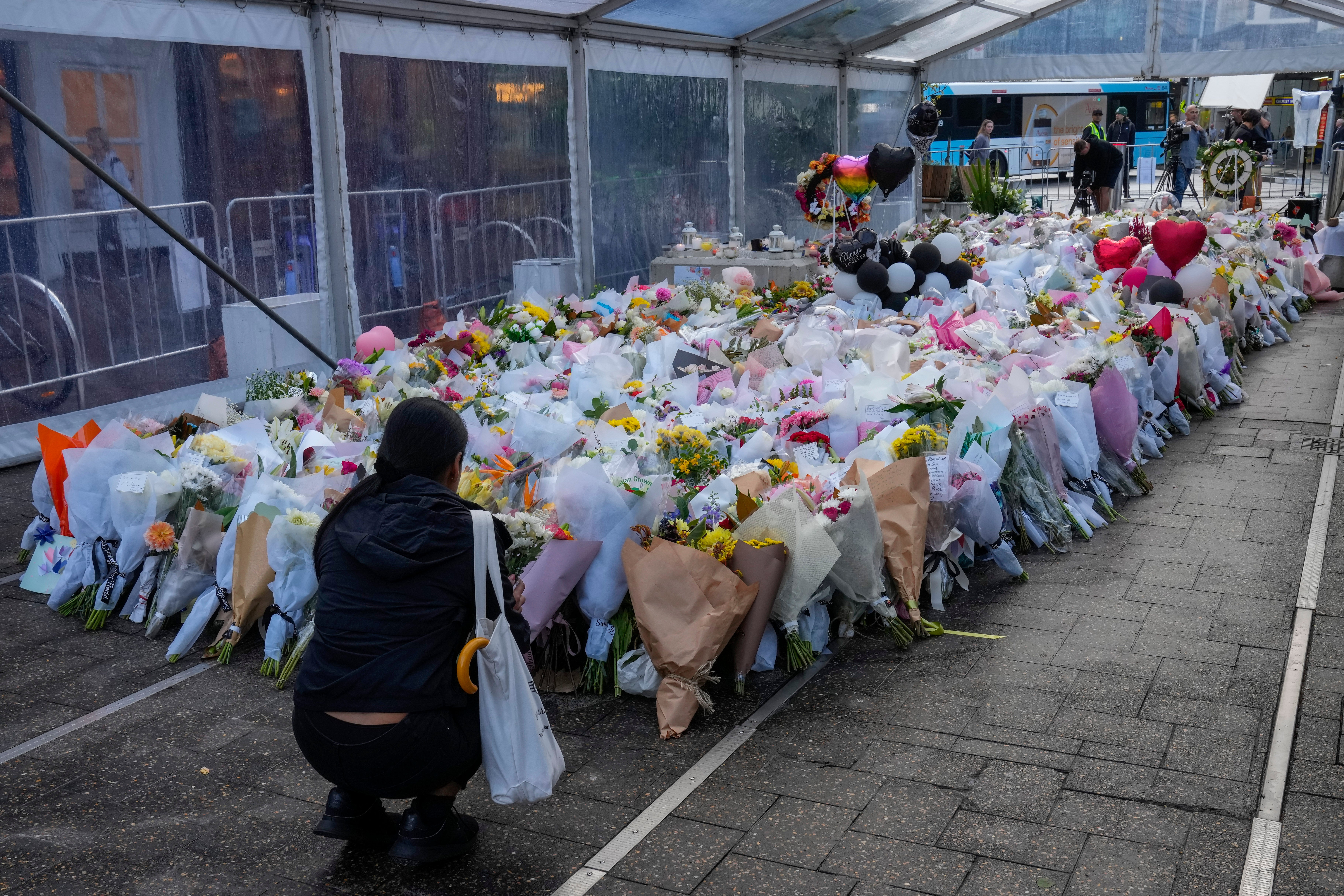 <p>A woman lays flowers at a tribute for the victims of  knife attack near a crime scene at Bondi Junction in Sydney</p>