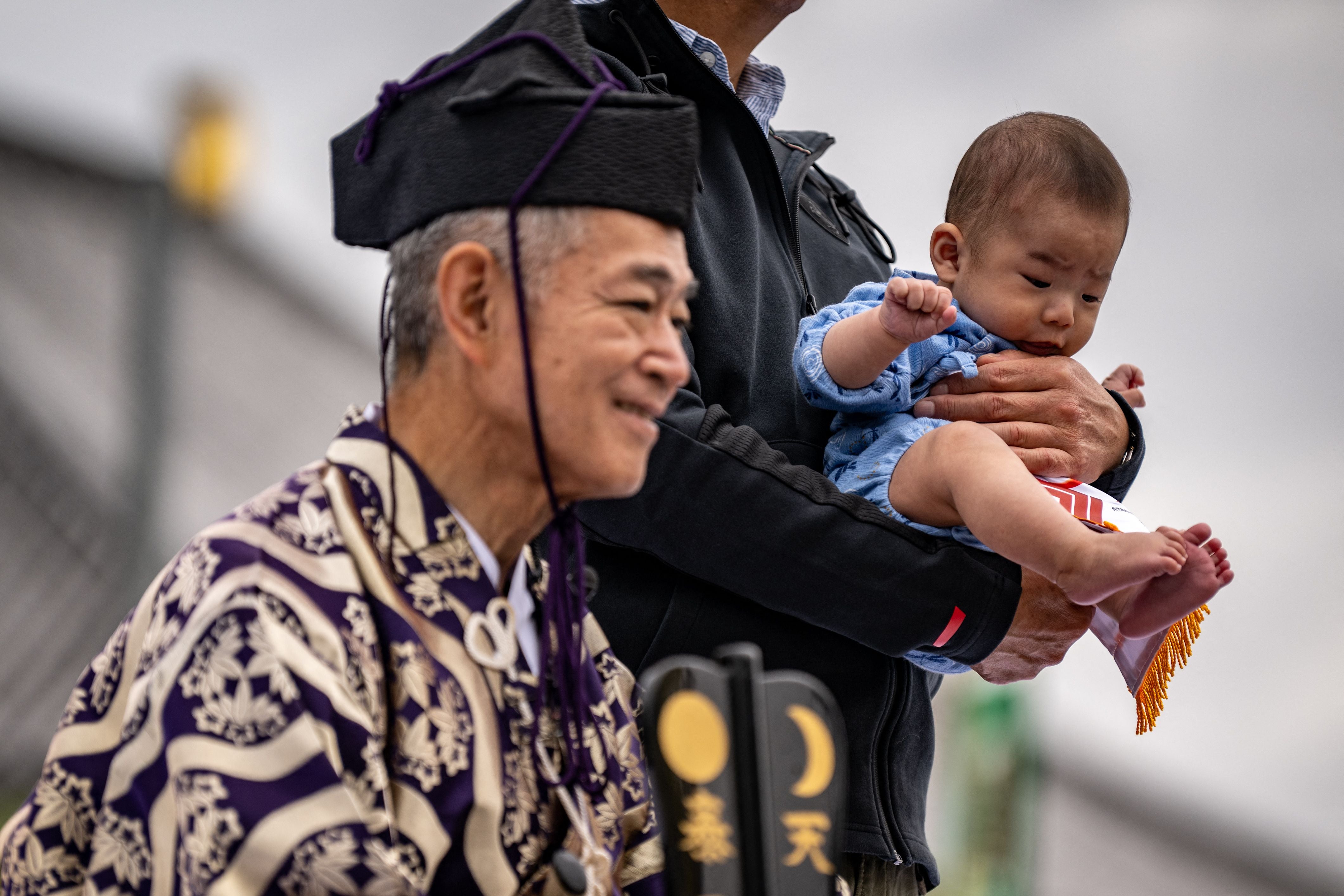 A parent holds his child for a photo call at the Sensoji temple in Tokyo
