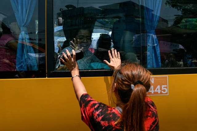 <p>A woman touches a bus carrying prisoners being released from Insein prison for the Buddhist New Year</p>
