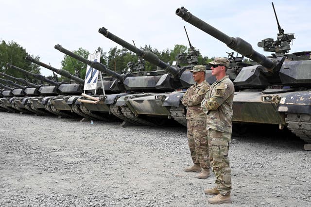 <p>US soldiers stand in front of military tanks at the United States Army military training base in Grafenwoehr, southern Germany</p>