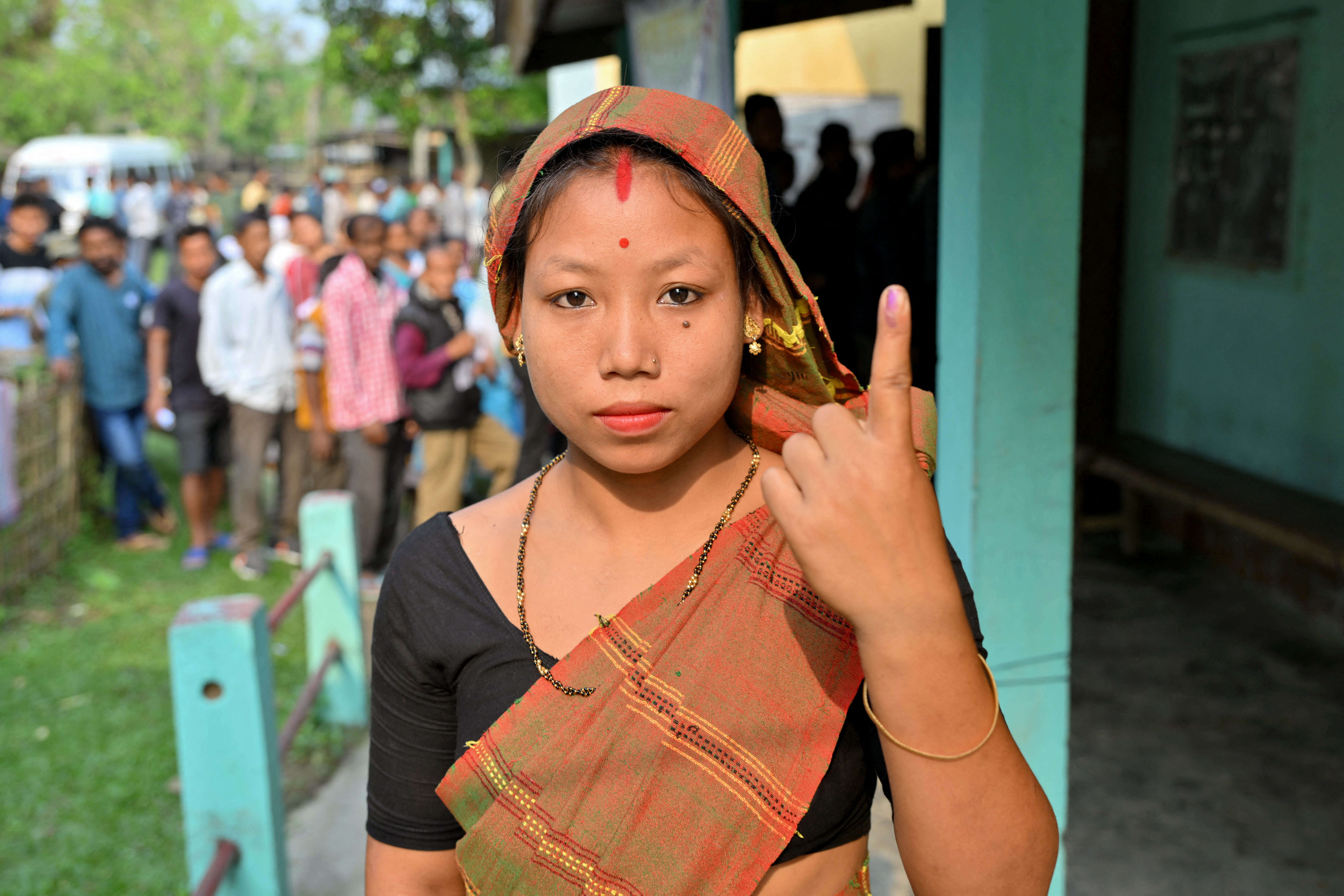 A woman shows her inked finger after casting her ballot in India’s general election at a polling station in Nagaon in the northeastern state of Assam on 19 April 2024