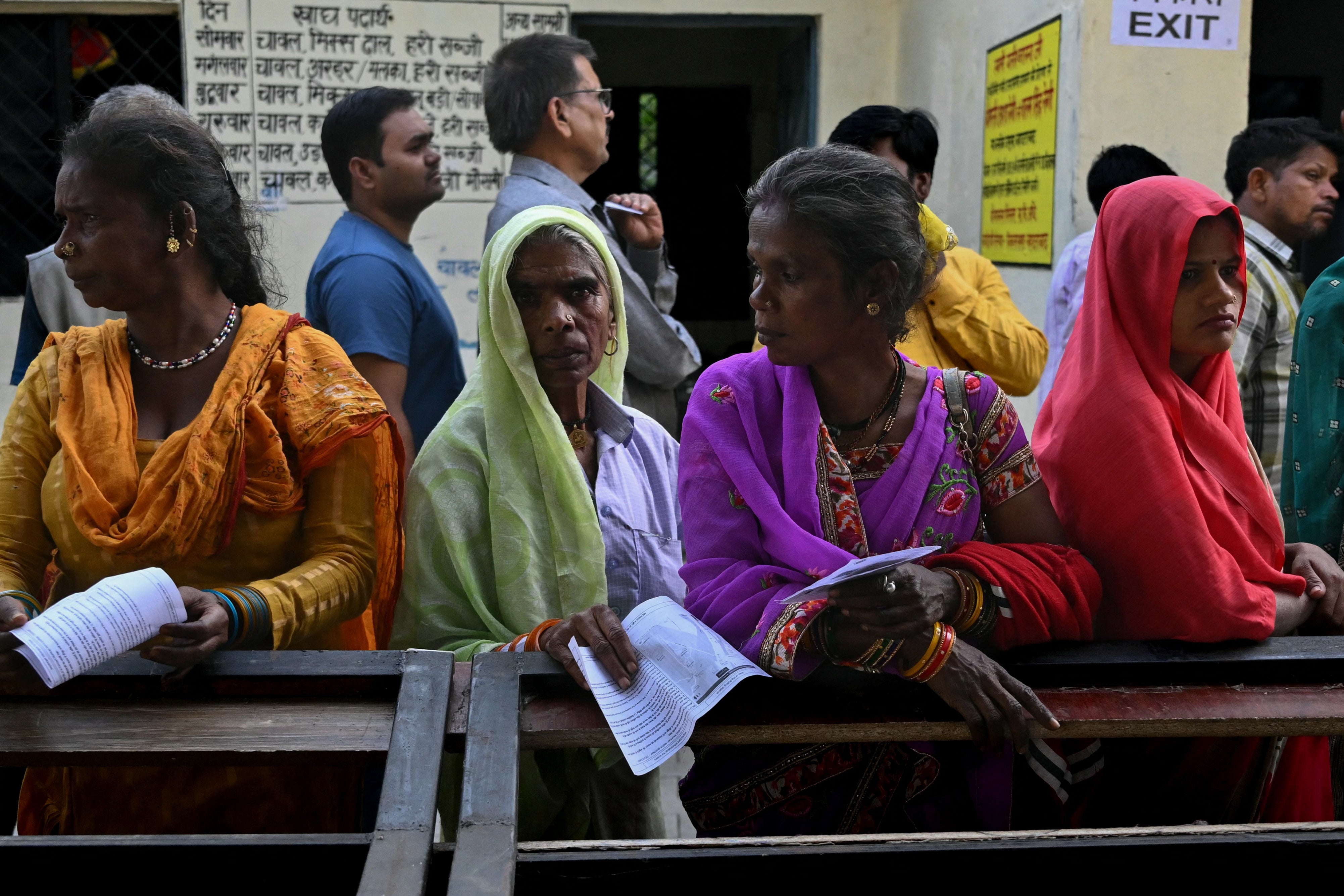 People stand in a queue to cast their votes at a polling station in Haridwar in the northern Uttarakhand state on 19 April 2024