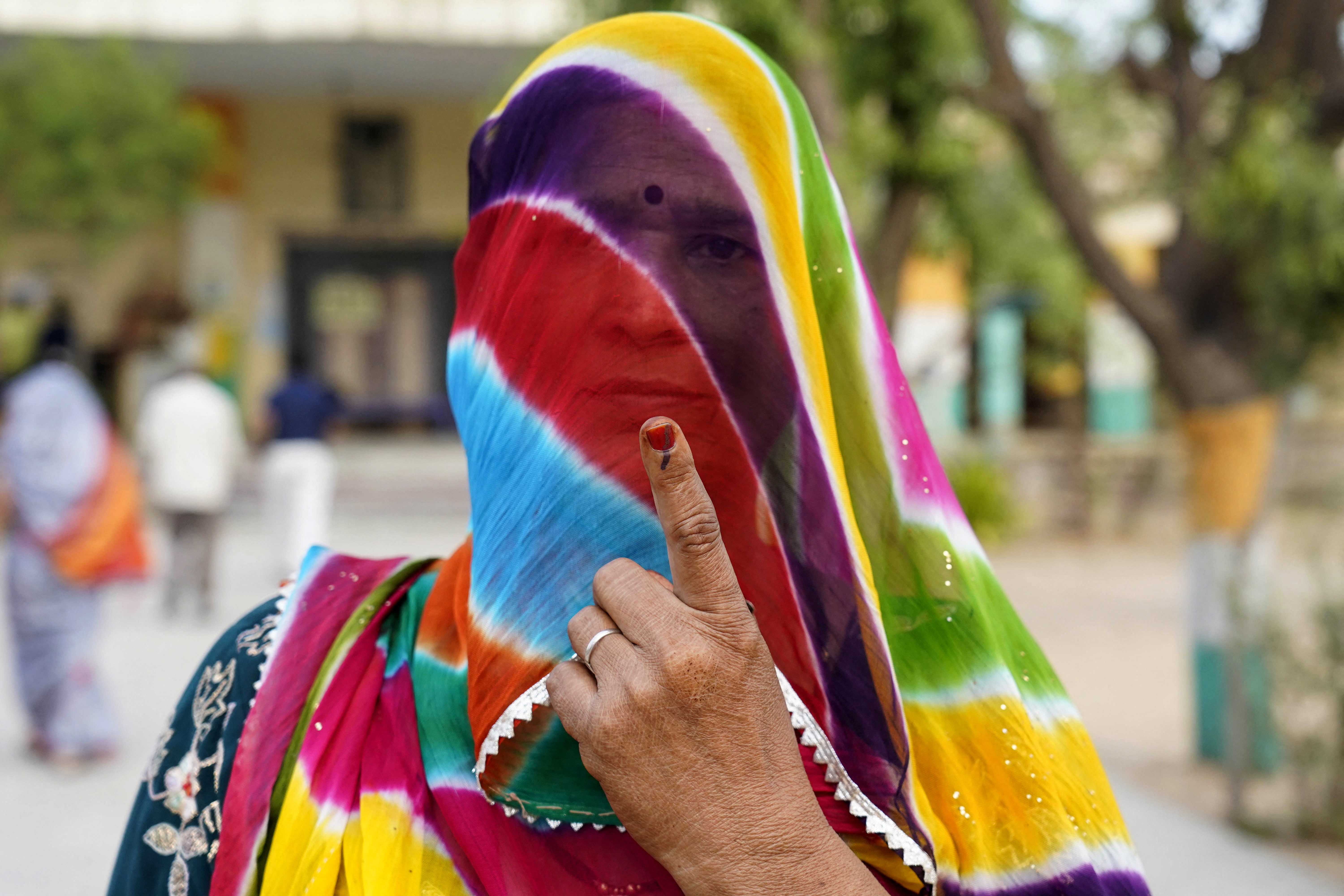 A woman shows her inked finger after casting her vote in India’s general elections at a polling station in Nagaur in the western state of Rajasthan on 19 April 2024