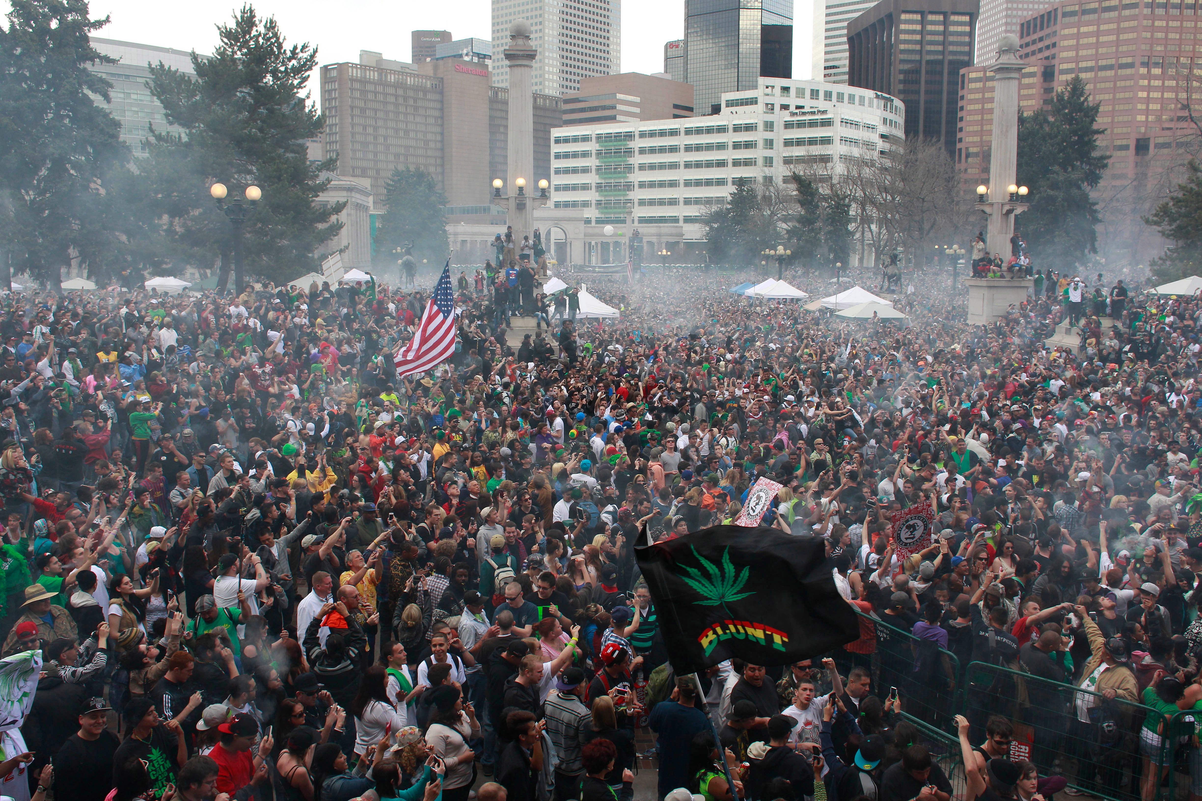 Members of a crowd numbering tens of thousands smoke marijuana and listen to live music at the Denver 420 pro-marijuana rally at Civic Center Park in Denver on 20 April 2013