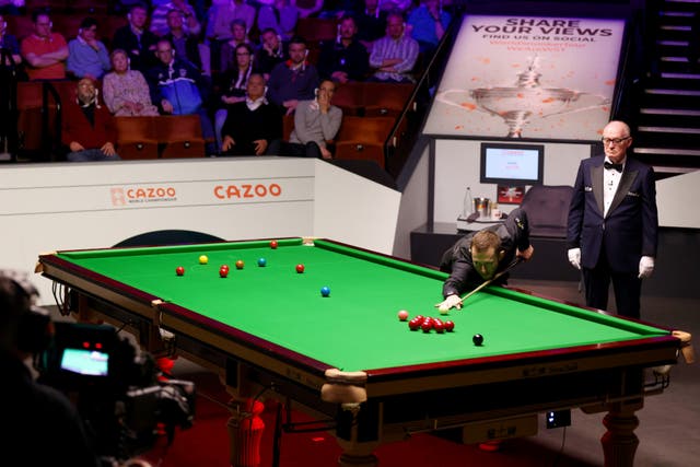<p>Mark Allen goes for a pot in the championship last year during a match against Mark Selby</p>