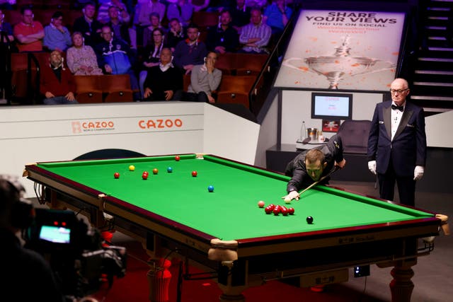 <p>Mark Allen goes for a pot in the championship last year during a match against Mark Selby</p>