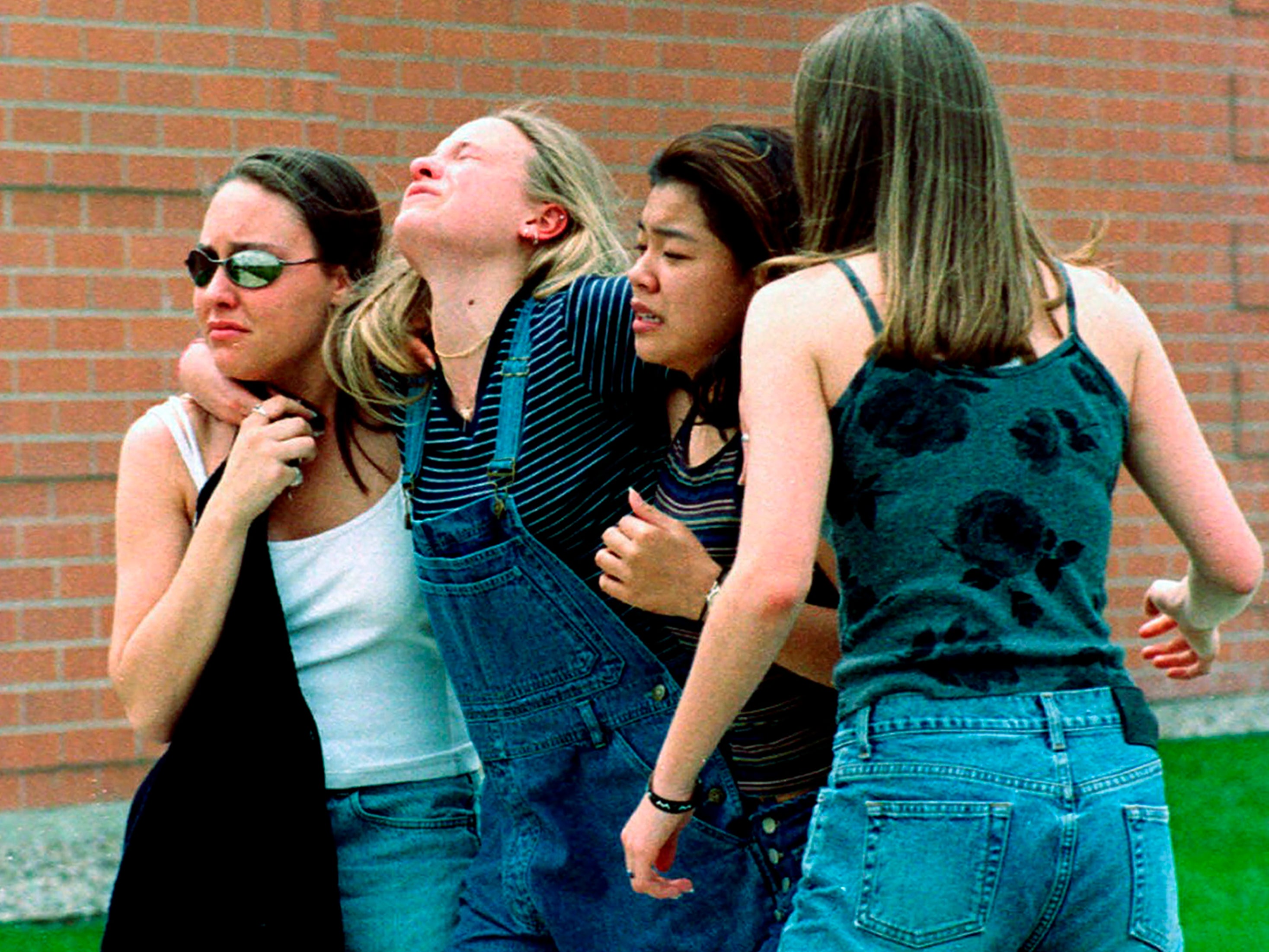 Young women head to a library near Columbine High School where students and faculty members were evacuated during the 1999 shooting