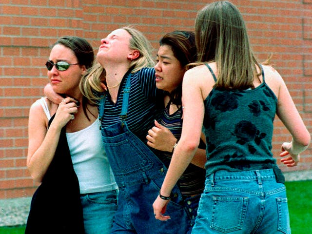 <p>Young women head to a library near Columbine High School where students and faculty members were evacuated during the 1999 shooting</p>