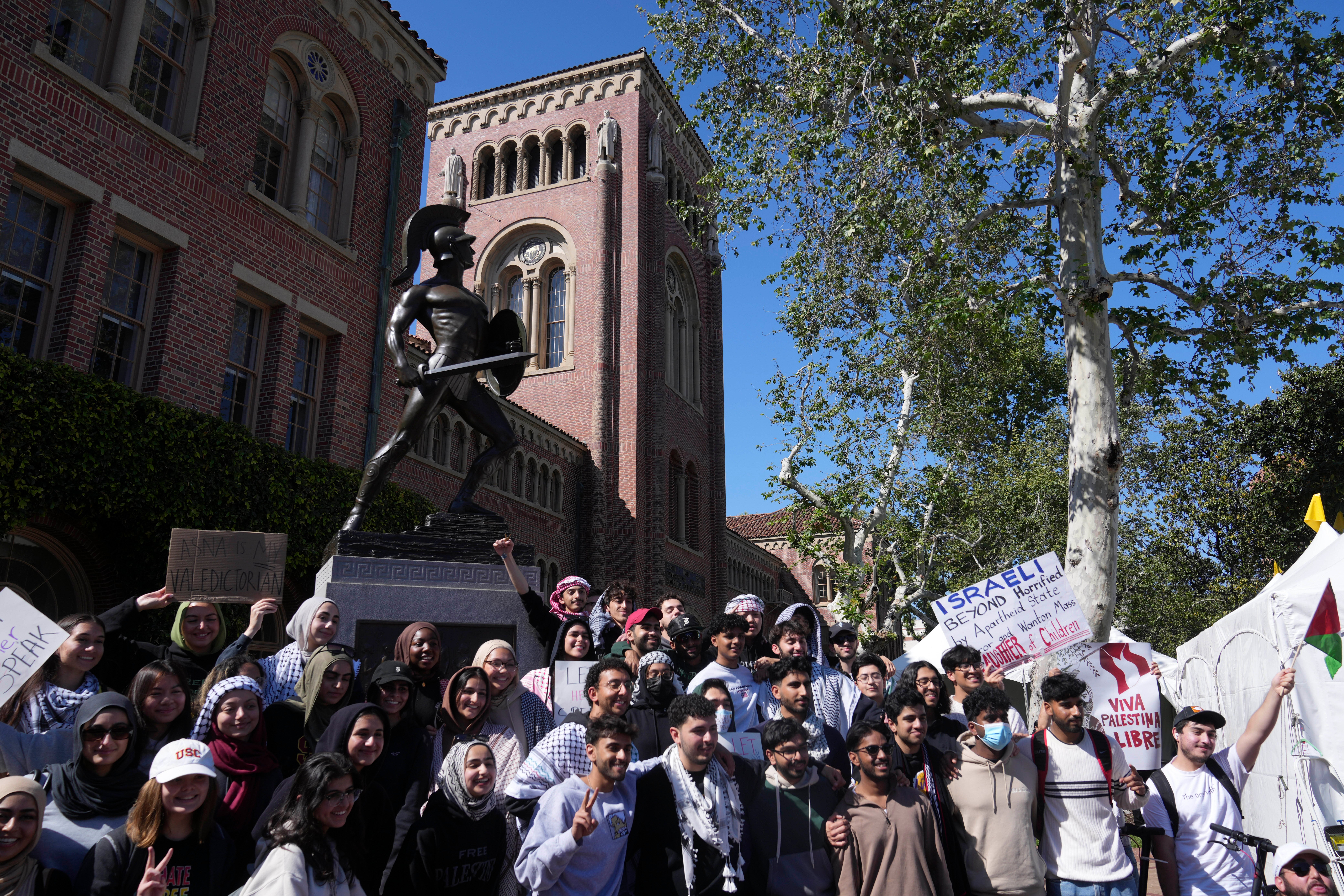 Pro-Palestinian students pose for photos in front of the Tommy Trojan statue on the campus of the University of Southern California