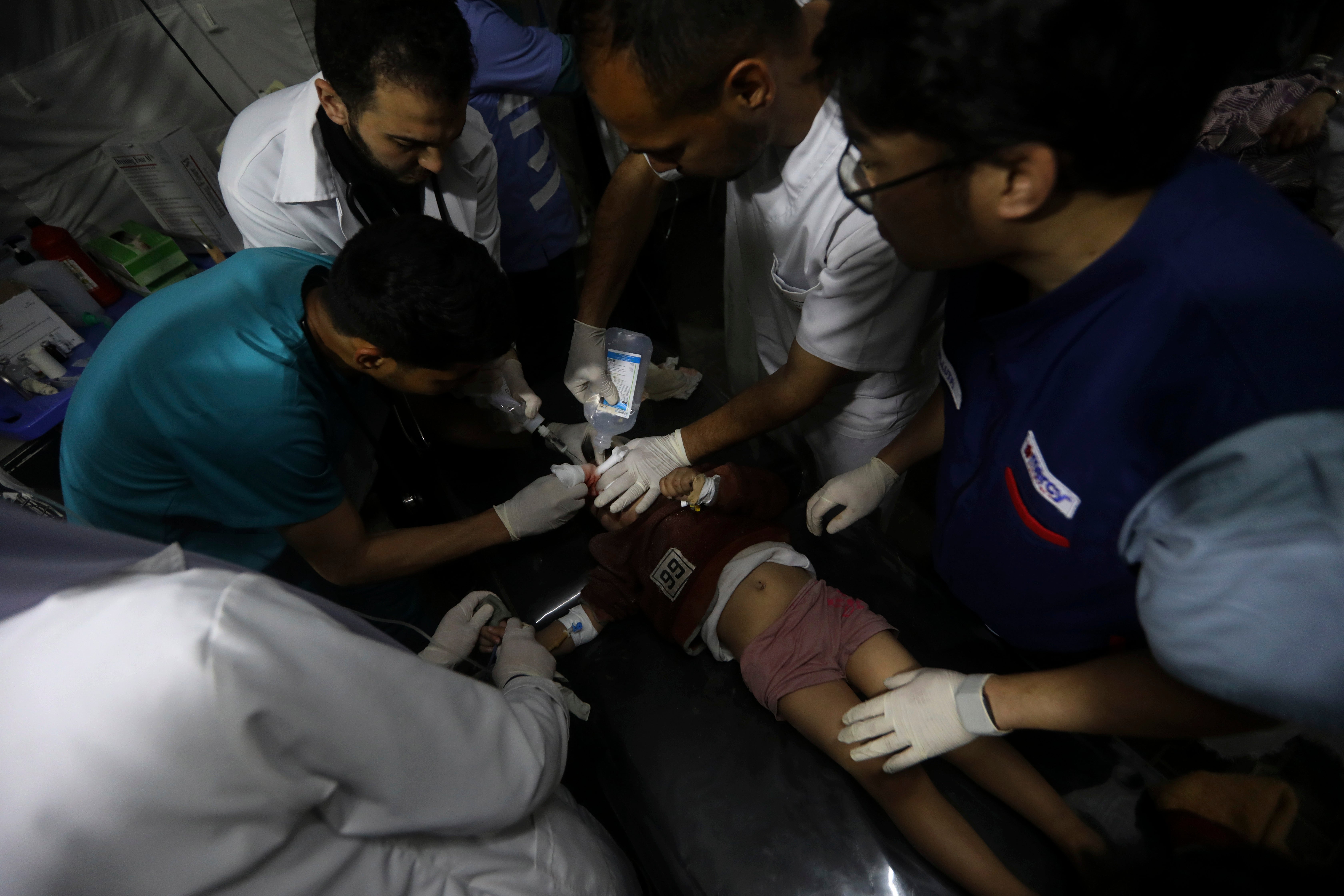 Palestinian medics treat a wounded in the Israeli bombardment of the Gaza Strip at the Kuwaiti Hospital