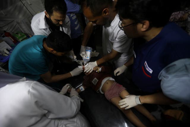 <p>Palestinian medics treat a wounded in the Israeli bombardment of the Gaza Strip at the Kuwaiti Hospital</p>