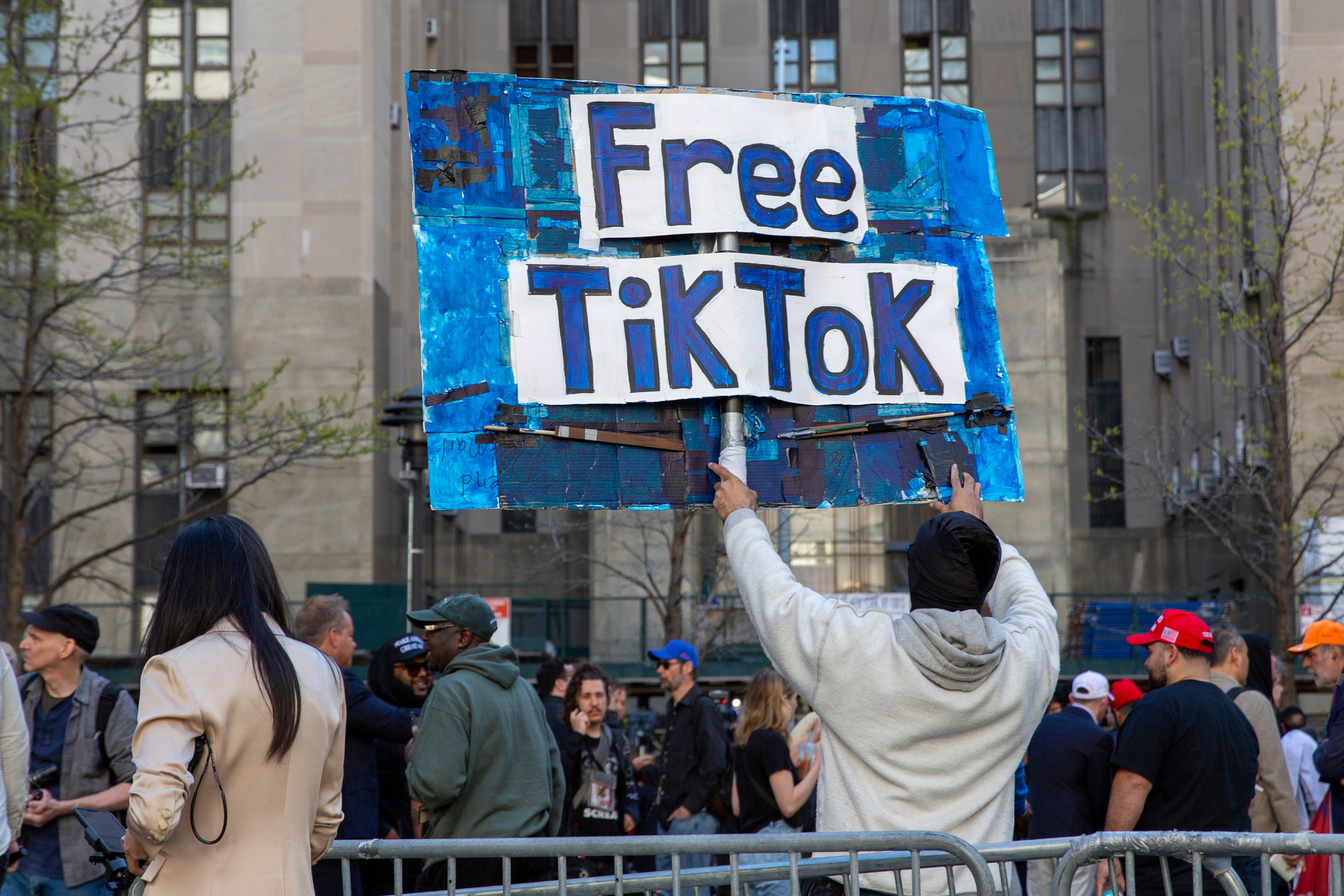 A man holds a ‘Free TikTok’ sign in front of the courthouse where the hush money trial is underway ahead of the House’s passage of the bill
