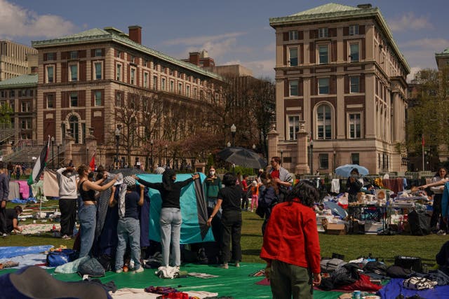 <p>Students hold up sheets while a person is being treated for a medical emergency, during a protest in support of Palestinians at Columbia University</p>