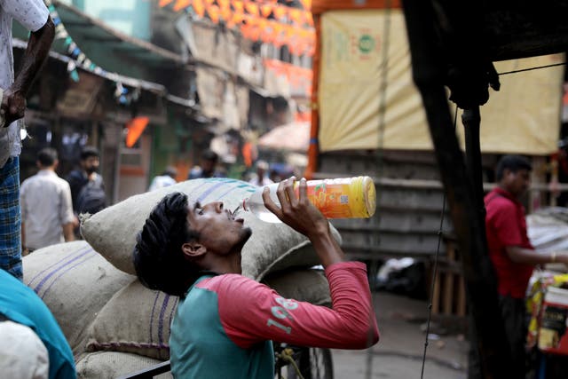 <p>An Indian labourer drinks water during hot midday sun at Burabazar in Kolkata, eastern India</p>