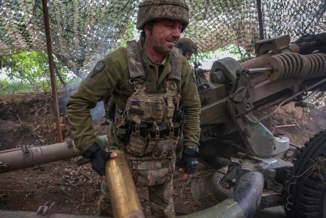 <p>Ukrainian service members fire a L119 howitzer towards Russian troops </p>