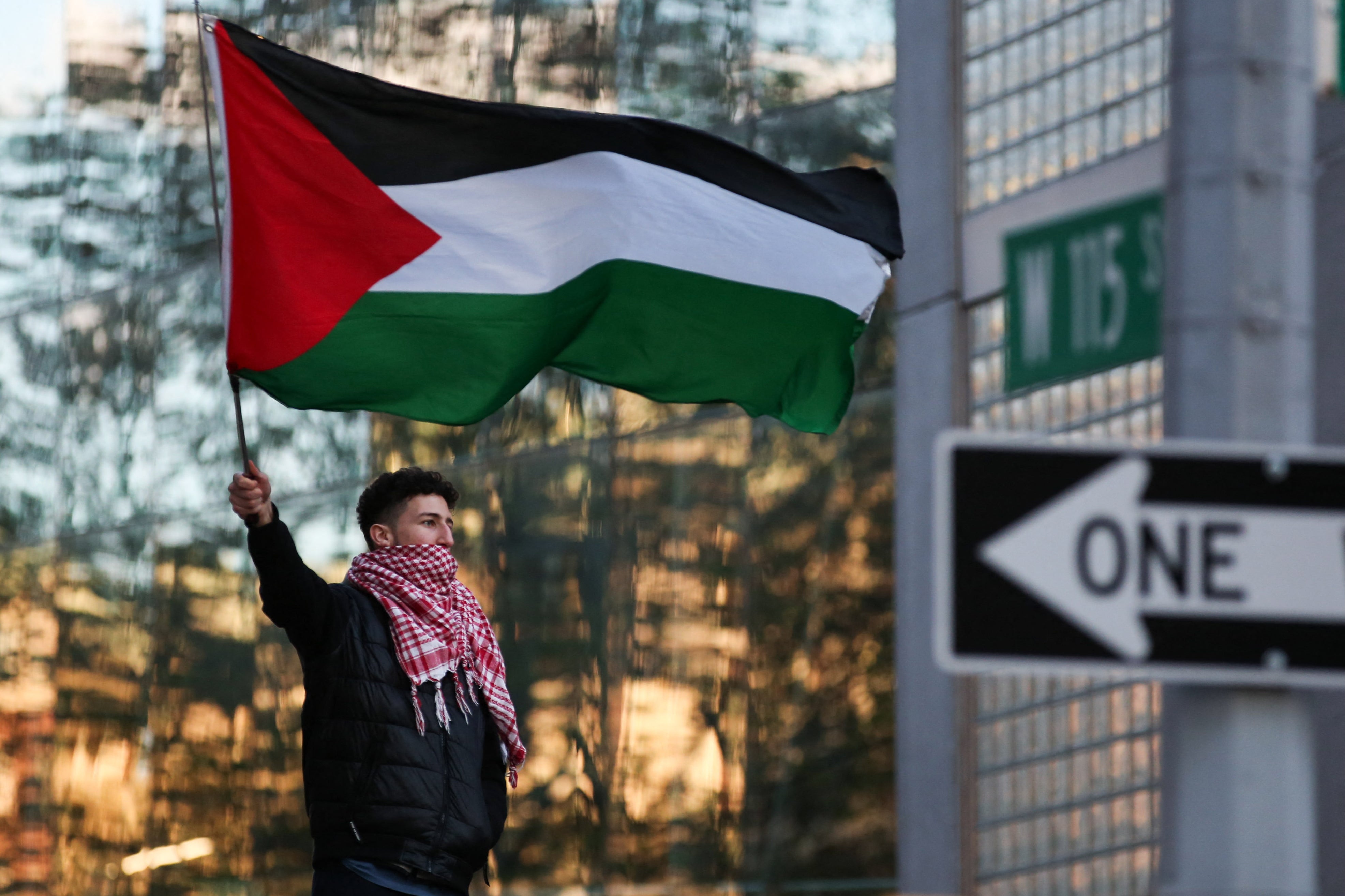 A man waves a Palestinian flag as pro-Palestinian activists protest outside Columbia University in New York City on 20 April 2024
