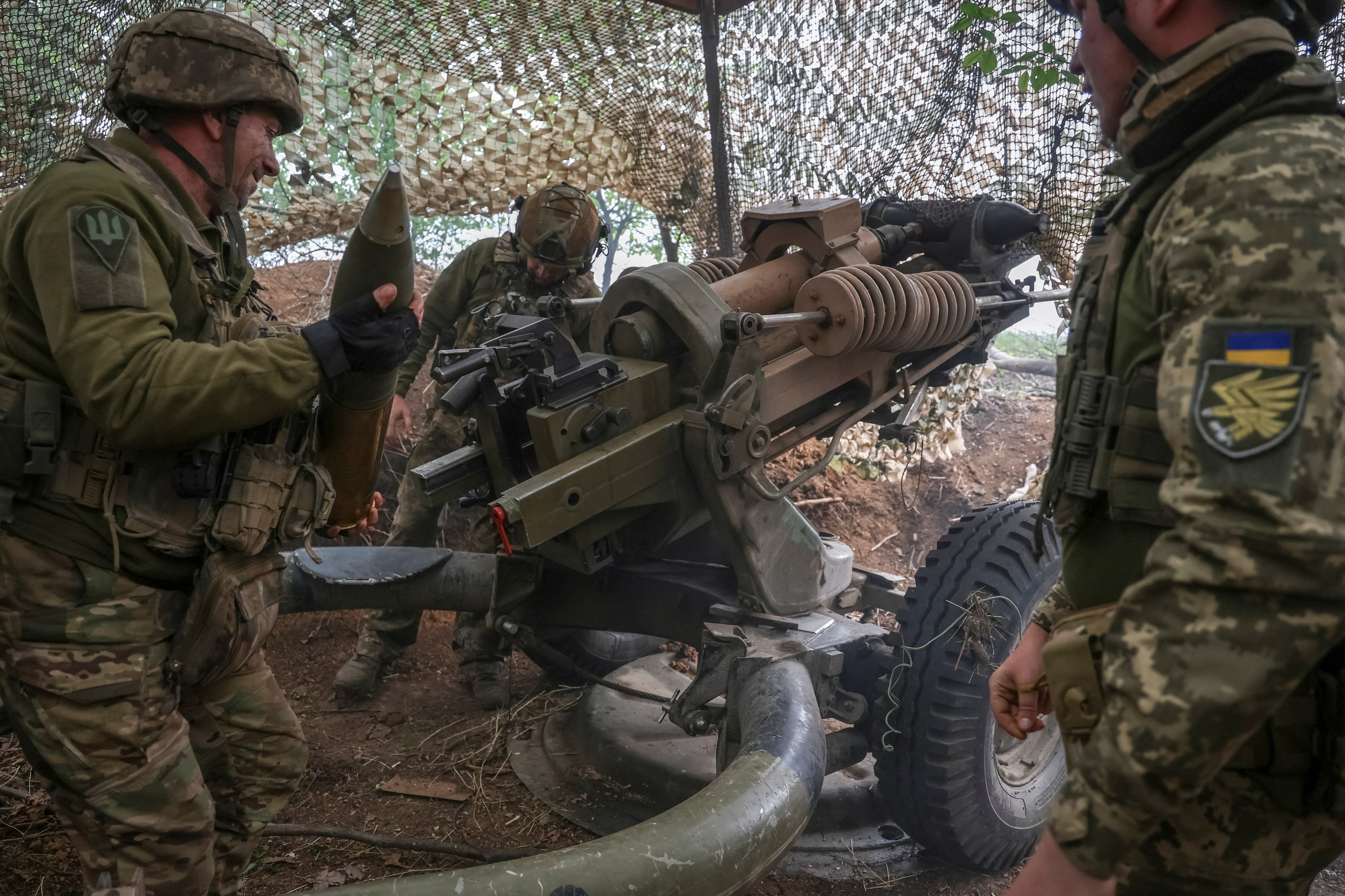 Ukrainian service members fire a L119 howitzer towards Russian troops in the eastern Donetsk region