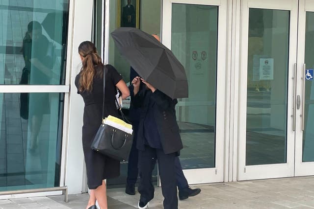 <p>Celebrity handbag designer Nancy Gonzalez hides under an umbrella as she walks with her lawyer Andrea Lopez outside the federal courthouse Monday, April 22, 2024, in Miami.</p>