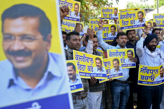 <p>Supporters of Aam Aadmi Party hold placards and posters featuring their leader and Delhi’s chief minister Arvind Kejriwal </p>