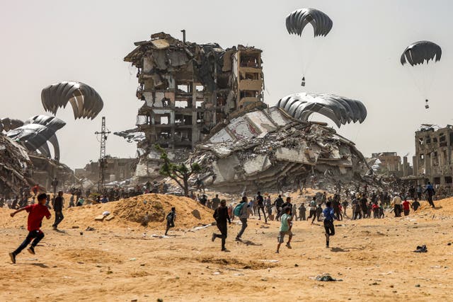 <p>People rush to landing humanitarian aid packages dropped over the northern Gaza Strip on 23 April, 2024</p>