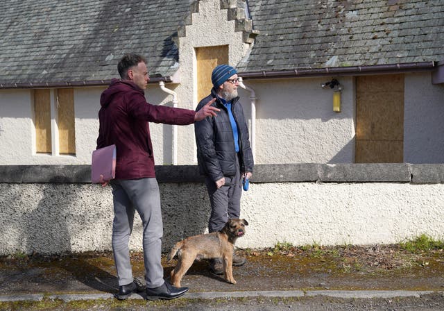 <p>Detective Constable Scott Young chats to locals as police make door-to-door enquiries in Aberfeldy, Perth and Kinross, during the investigation into the murder of Brian Low</p>