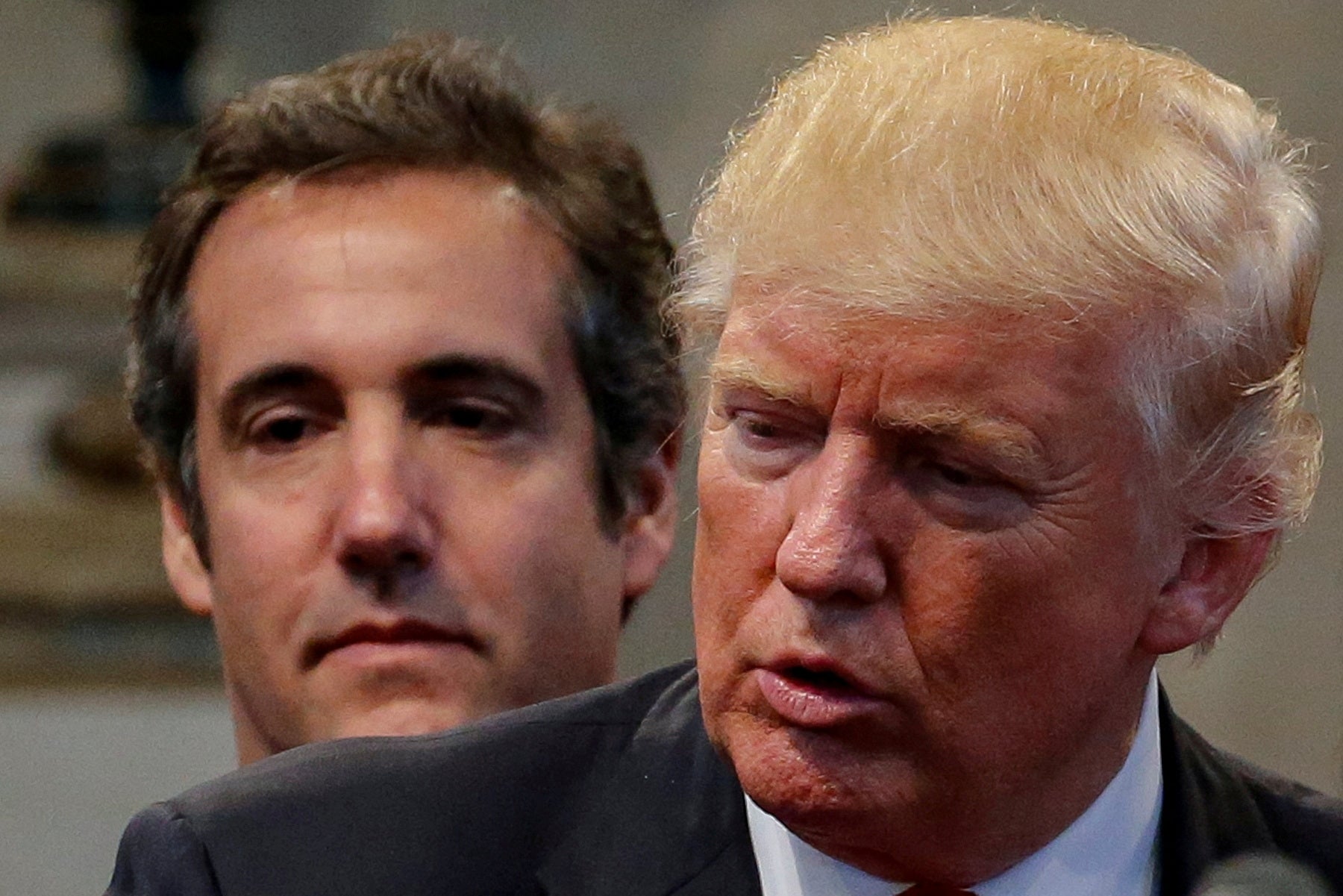 Donald Trump's personal attorney Michael Cohen stands behind Trump as he runs for president in 2016