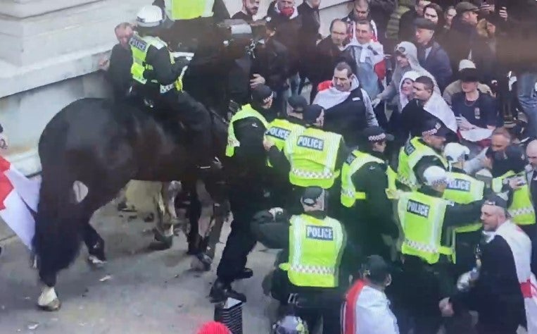 A police horse runs in to try and disperse crowd