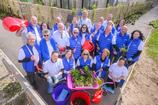 Lottery winners from across the UK help out with gardening at Alder Hey Children’s Hospital (Anthony Devlin/PA)