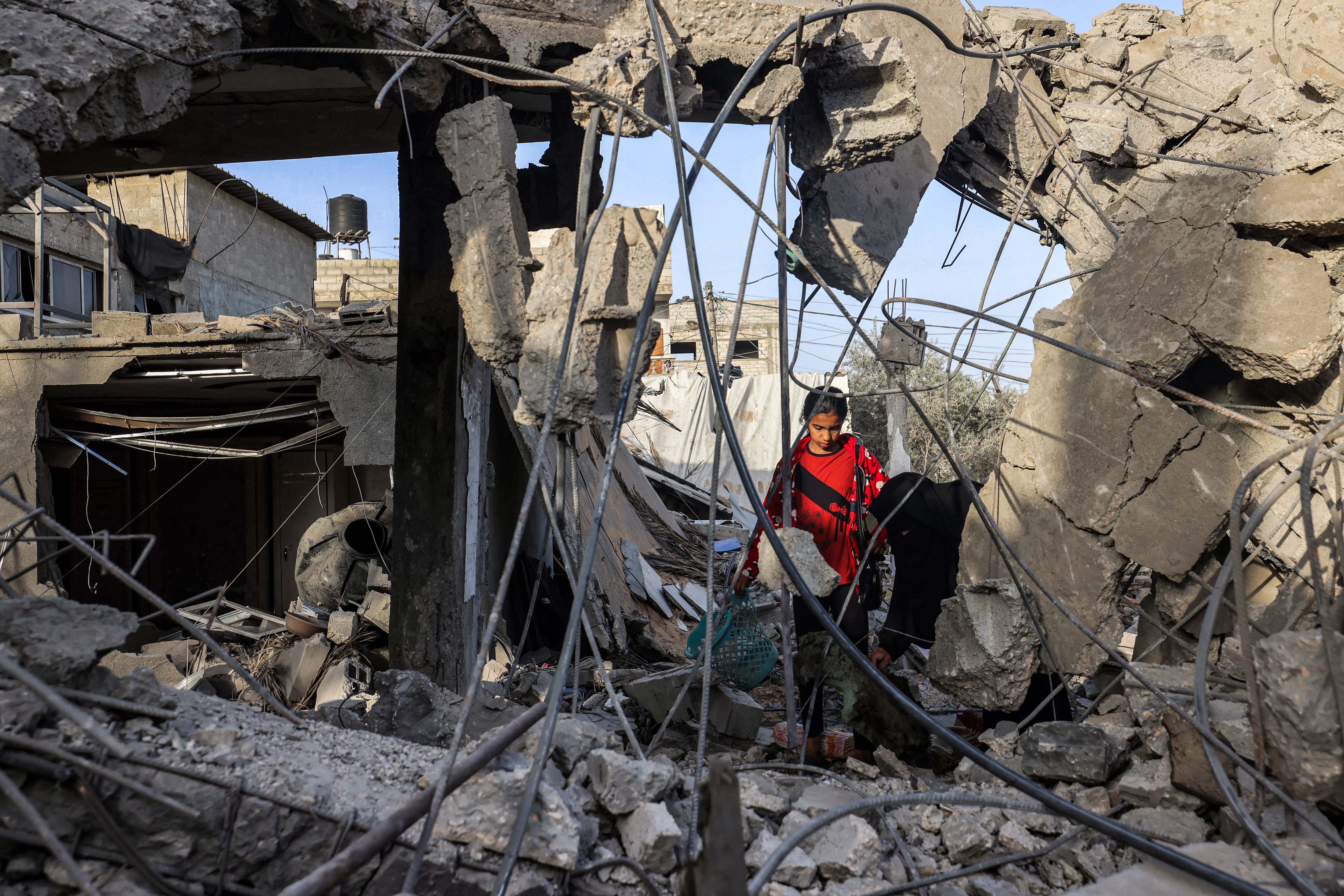 A woman and a girl search for items through the rubble of a collapsed building in Rafah in the southern Gaza Strip on April 24, 2024. Former house speaker Nancy Pelosi condemned Netanyahu for his actions in the territory on Wednesday