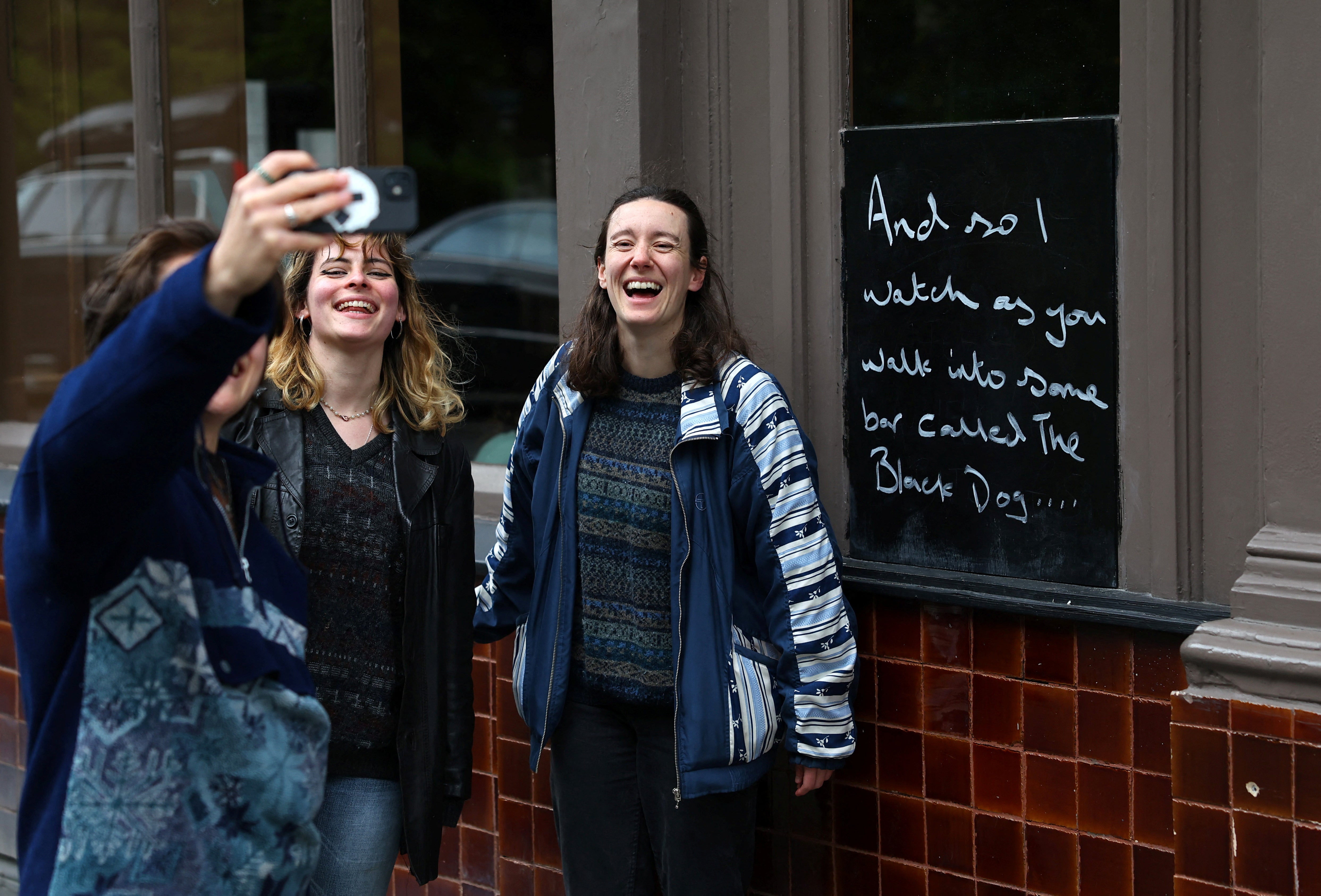 Fans of Taylor Swift take images next to lyrics from the song The Black Dog by Taylor Swift, written outside The Black Dog pub, believed by its owners to have been referenced in the track,