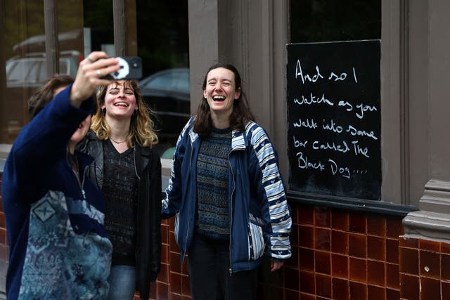 <p>Fans of Taylor Swift take images next to lyrics from the song The Black Dog by Taylor Swift, written outside The Black Dog pub, believed by its owners to have been referenced in the track,</p>