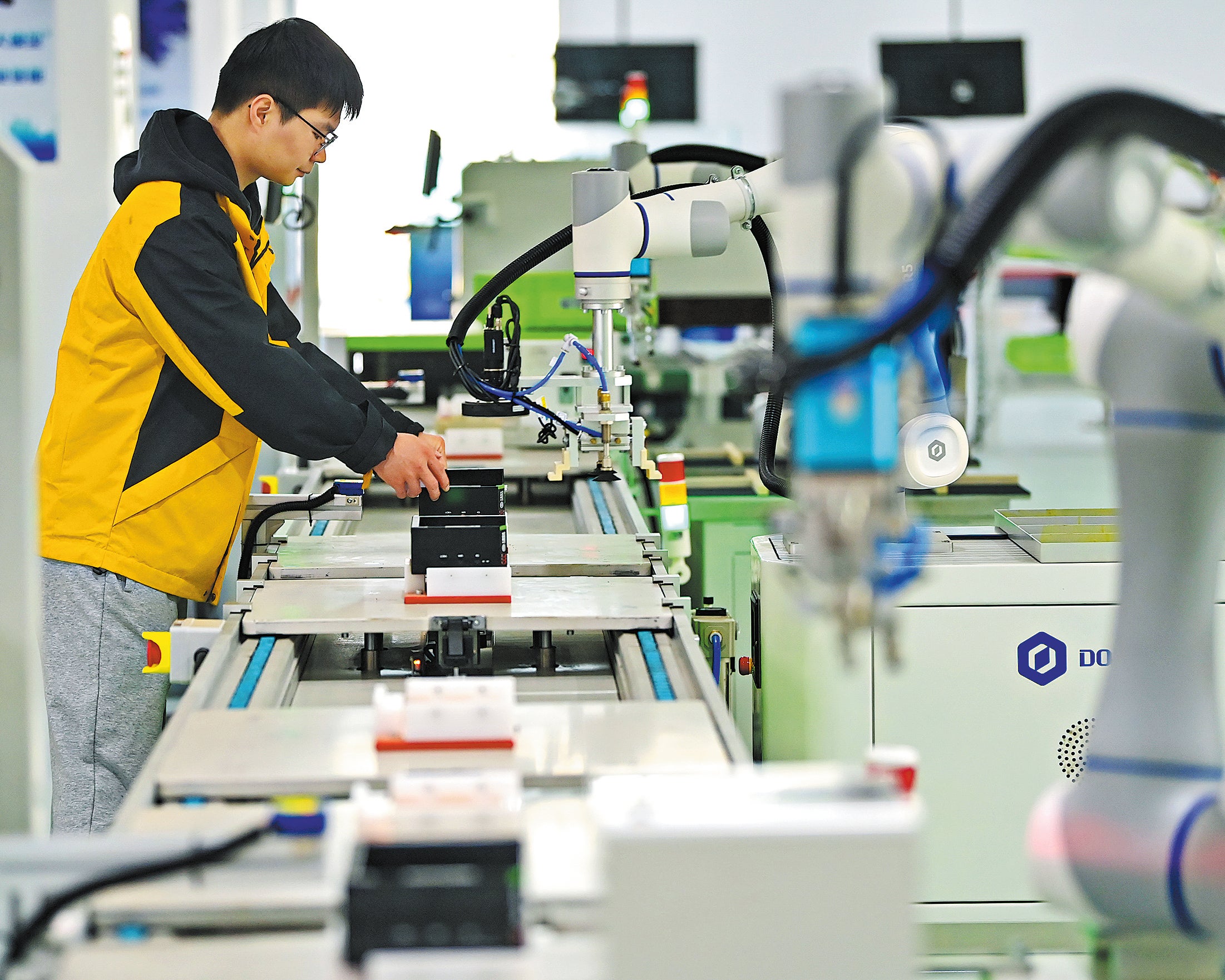 An employee checks intelligent manufacturing equipment at a tech company in Ganzhou, Jiangxi province