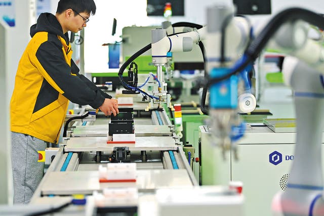 <p>An employee checks intelligent manufacturing equipment at a tech company in Ganzhou, Jiangxi province</p>