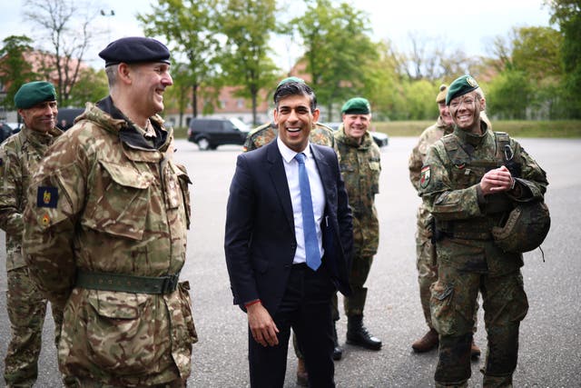 <p>Britain’s Prime Minister Rishi Sunak (C) speaks with military personnel as he visits the Julius Leber Barracks in Berlin.</p>