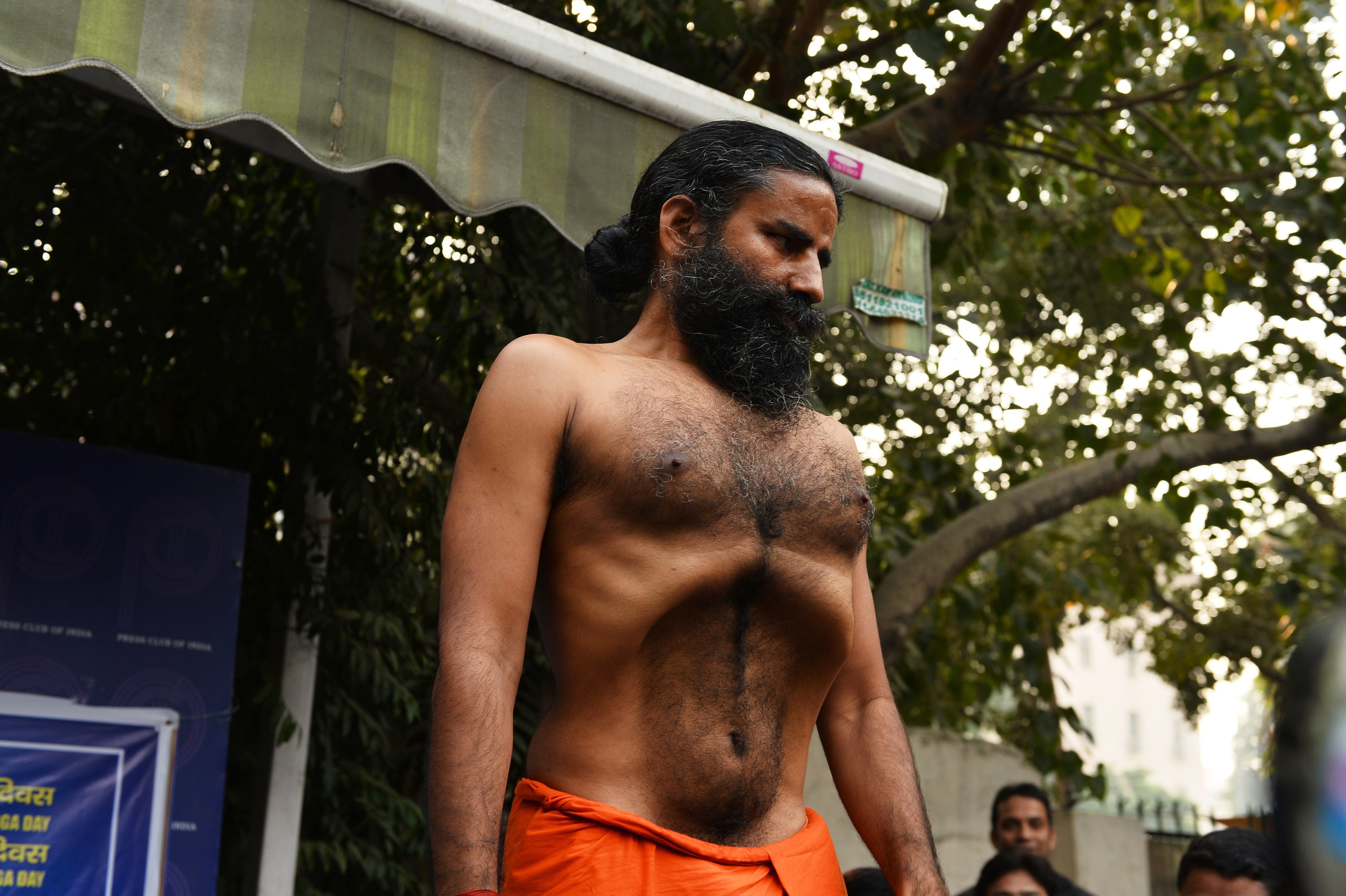Indian yoga guru, Baba Ramdev demonstrates a yoga exercise to the media during a press conference on the declaration of a ‘yoga day’ in New Delhi in 2014
