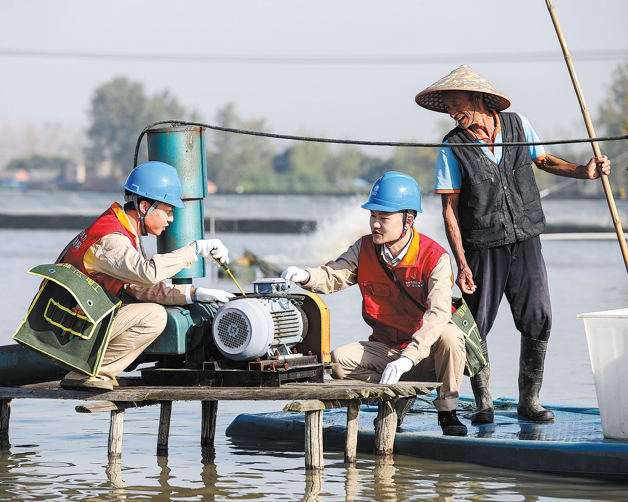 Electric power workers inspect oxygen supply equipment in a crab pond in Huai’an, Jiangsu province, in November