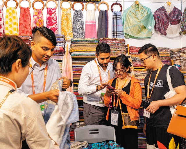 <p>Visitors purchase cashmere products through mobile payment methods in Nanning, Guangxi Zhuang autonomous region </p>