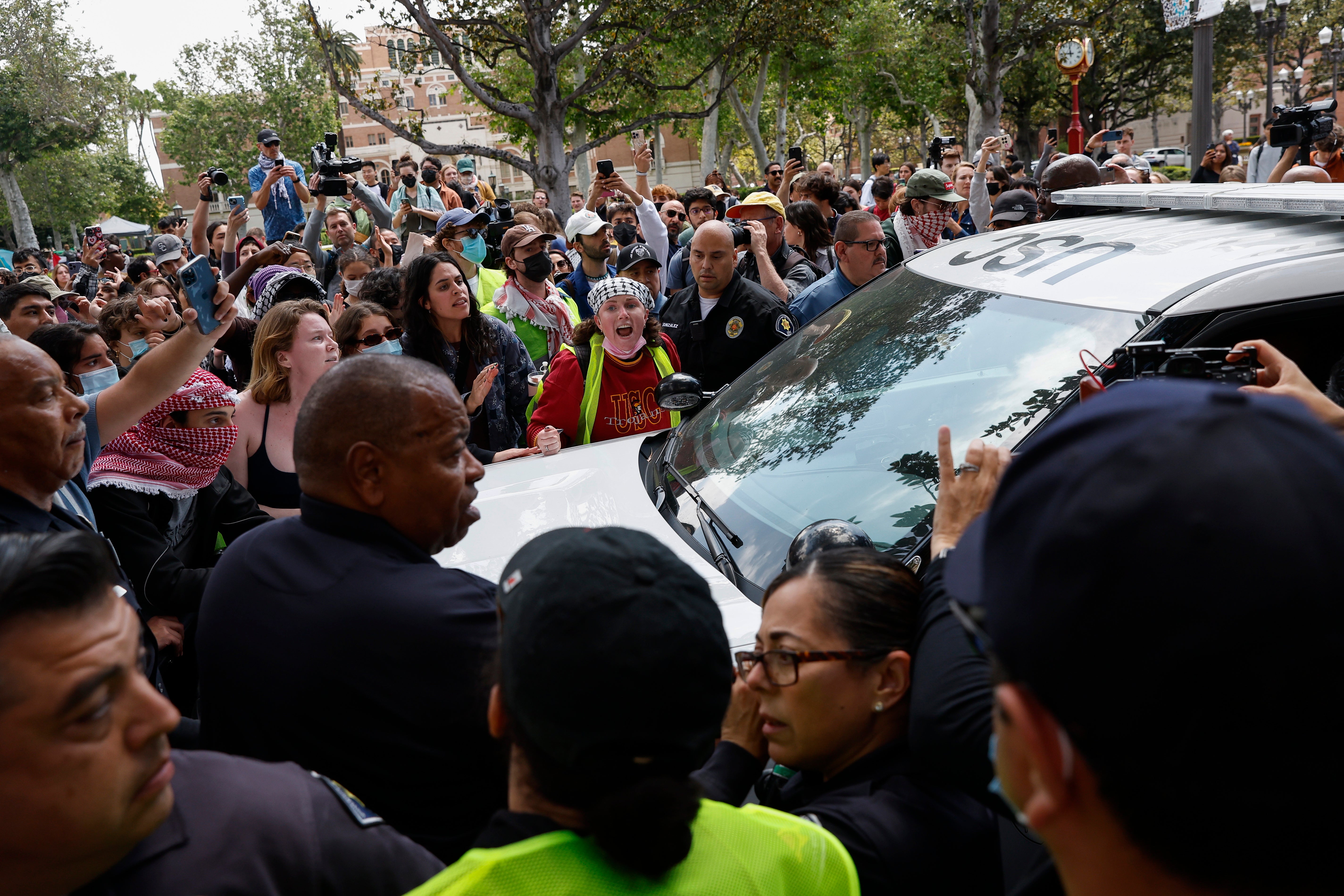 Students and community members clash with USC Public Safety Officers during a Gaza solidarity occupation on campus, with demonstrators blocking a car trying to remove an arrested individual