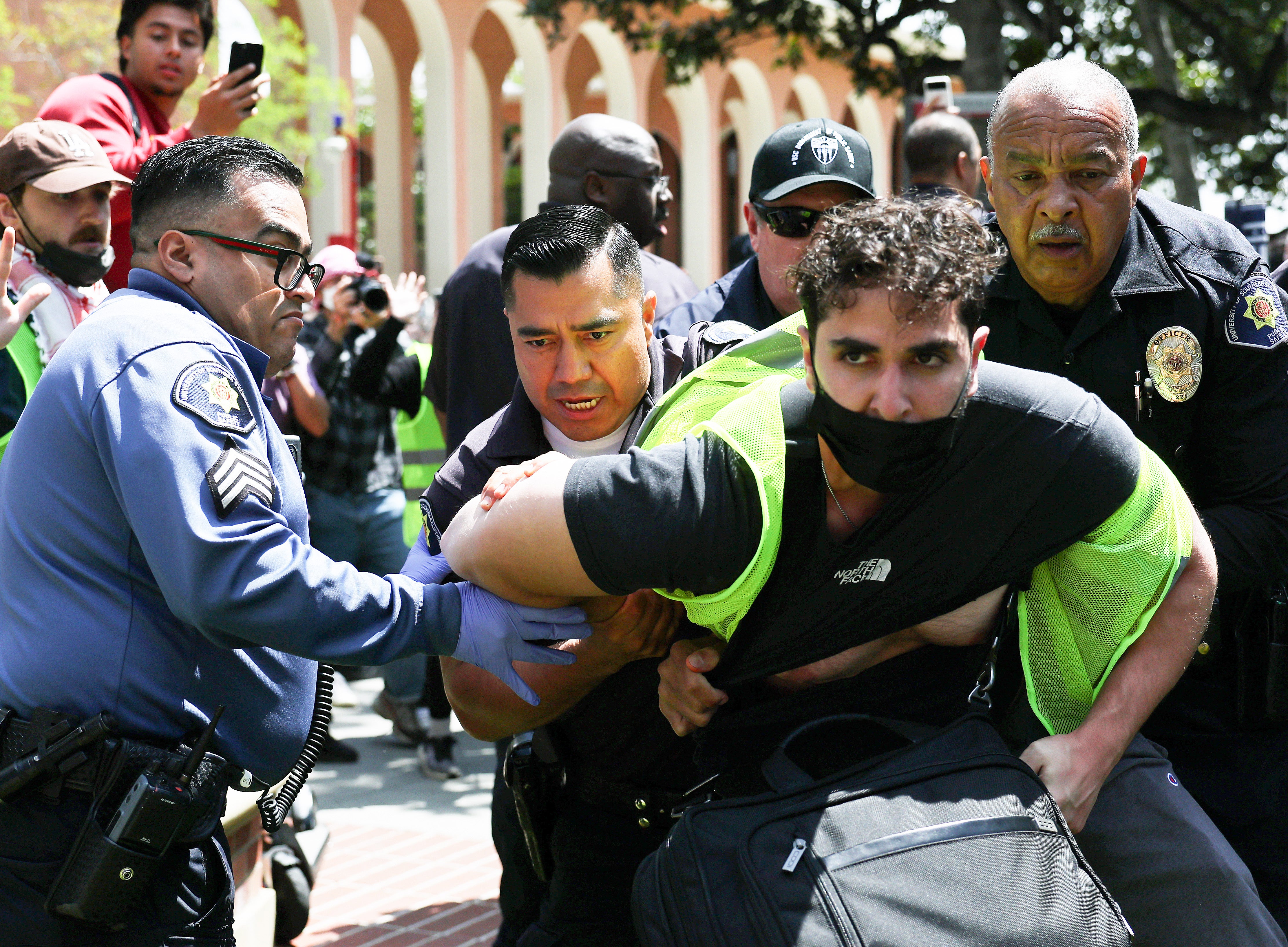 USC public safety officers detain a pro-Palestine demonstrator during clashes after officers attempted to take down an encampment in support of Gaza