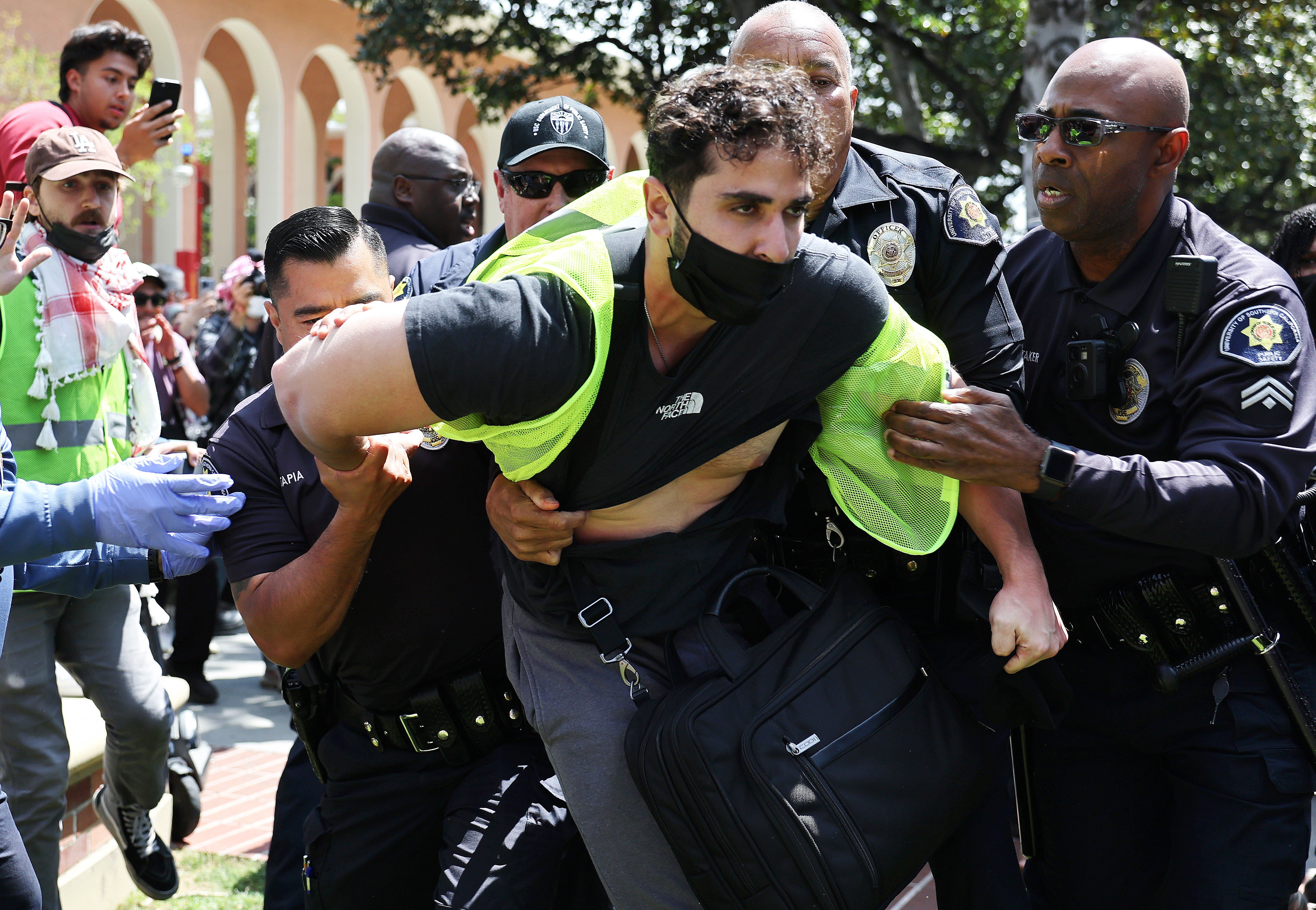 USC public safety officers detain a pro-Palestine demonstrator during clashes after officers attempted to take down an encampment