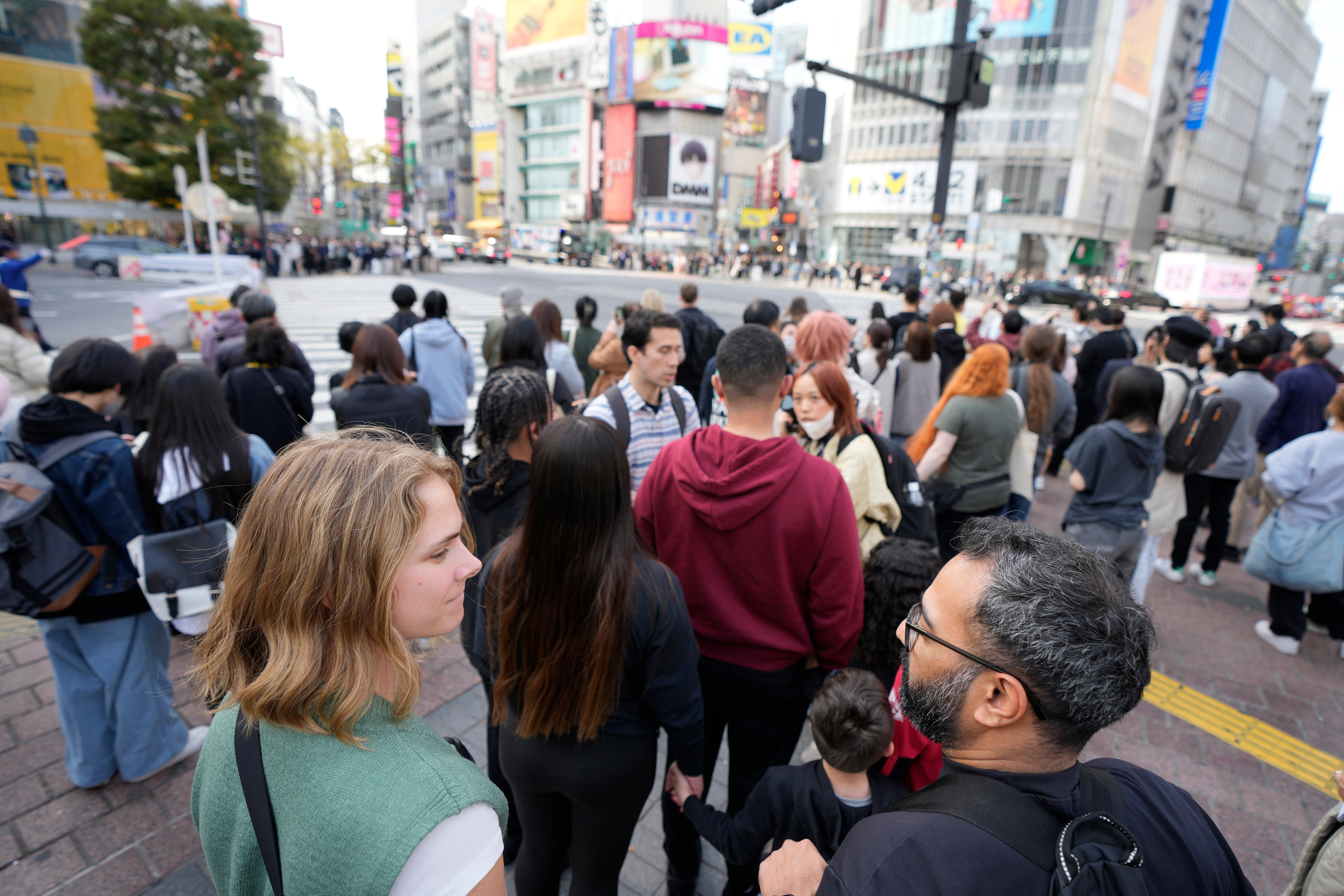 Frank Striegl, center, a guide of Tokyo Ramen Tours, leads several participants of a ramen tasting tour near Shibuya pedestrian crossing at Shibuya district on April 2, 2024, in Tokyo