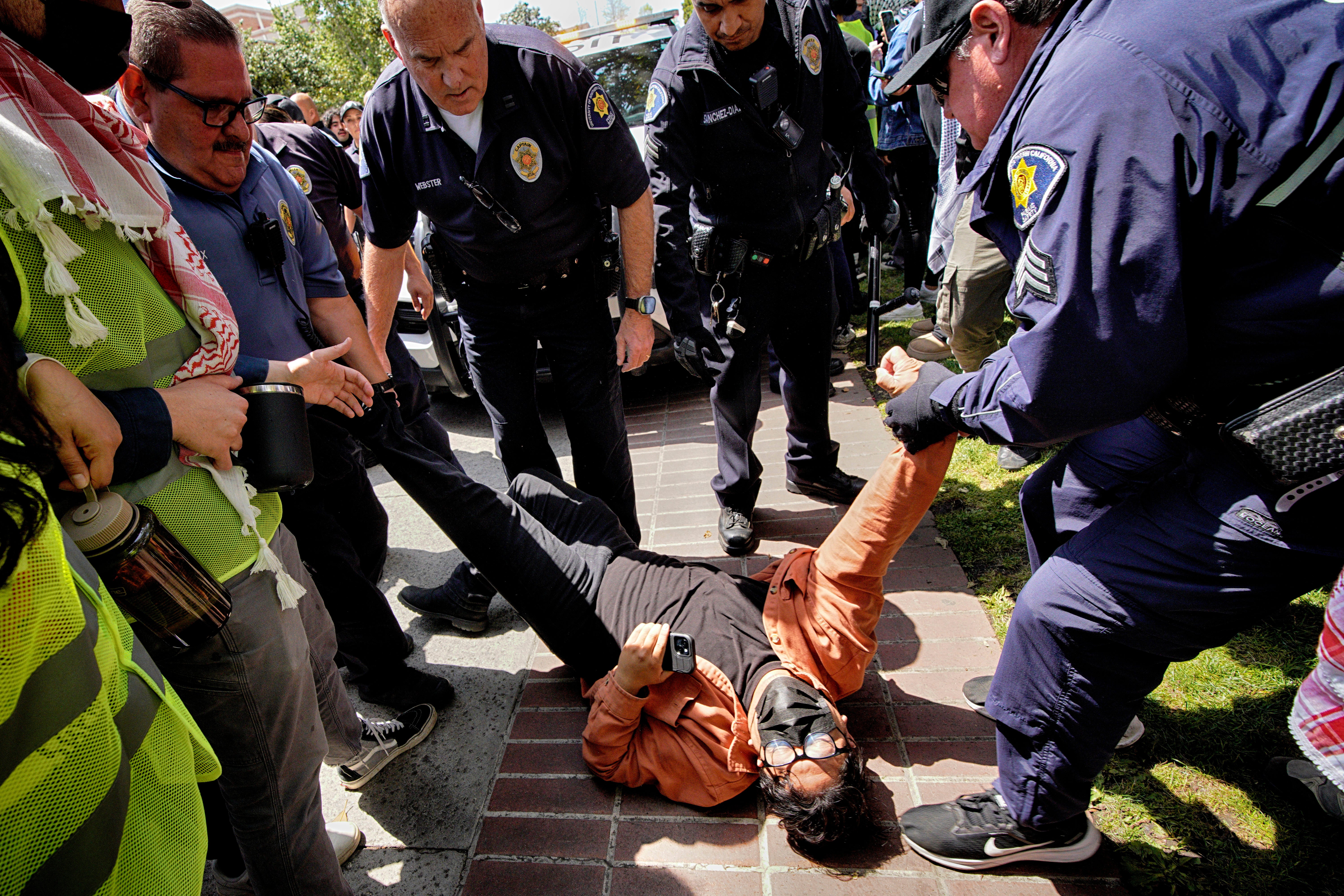 A protester at USC is detained by campus security following clashes at the university on Wednesday 24 April