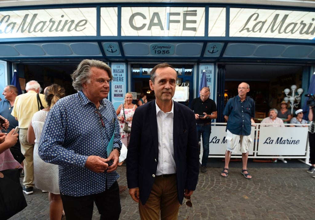 Robert Menard, mayor of Beziers, (R) speaks with Gilbert Collard (L), France's far-right National Front (FN) party candidate