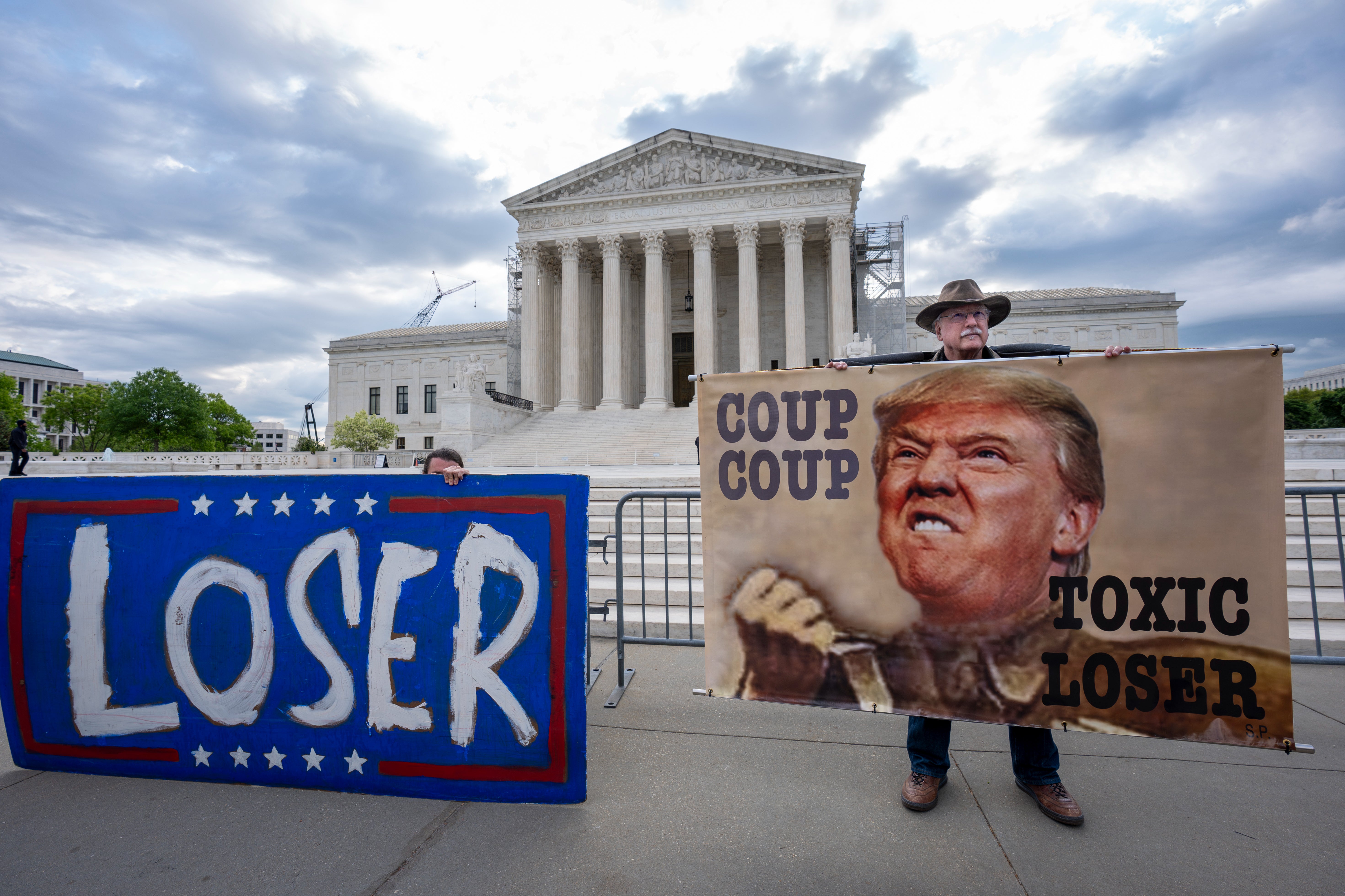 Activist Stephen Parlato of Boulder, Colo., right, joins other protesters outside the Supreme Court as the justices prepare to hear arguments over whether Donald Trump is immune from prosecution in a case charging him with plotting to overturn the results of the 2020 presidential election, on Capitol Hill in Washington, Thursday, April 25, 2024