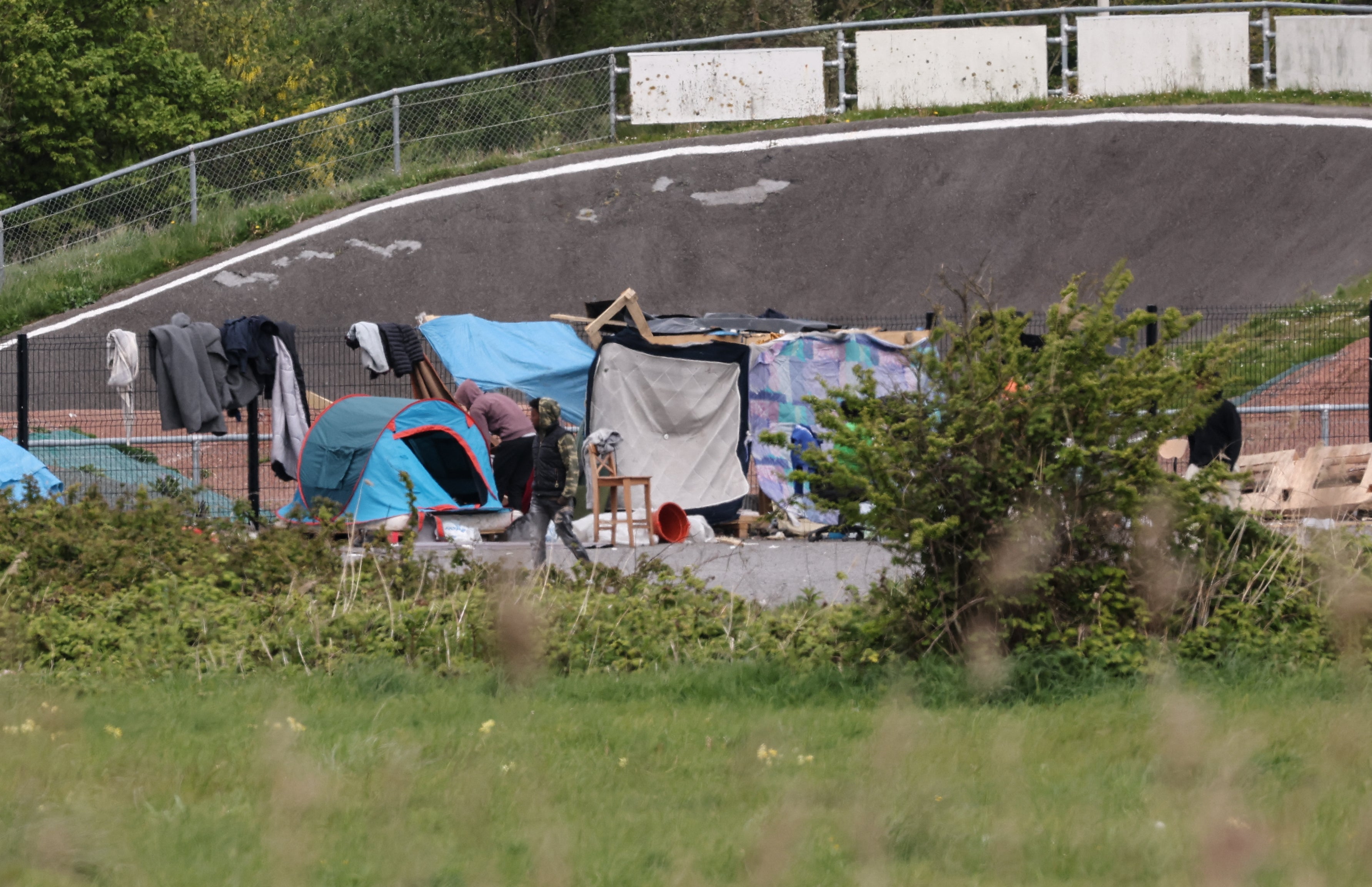 Migrants wander around a makeshift camp near Calais on 23 April.